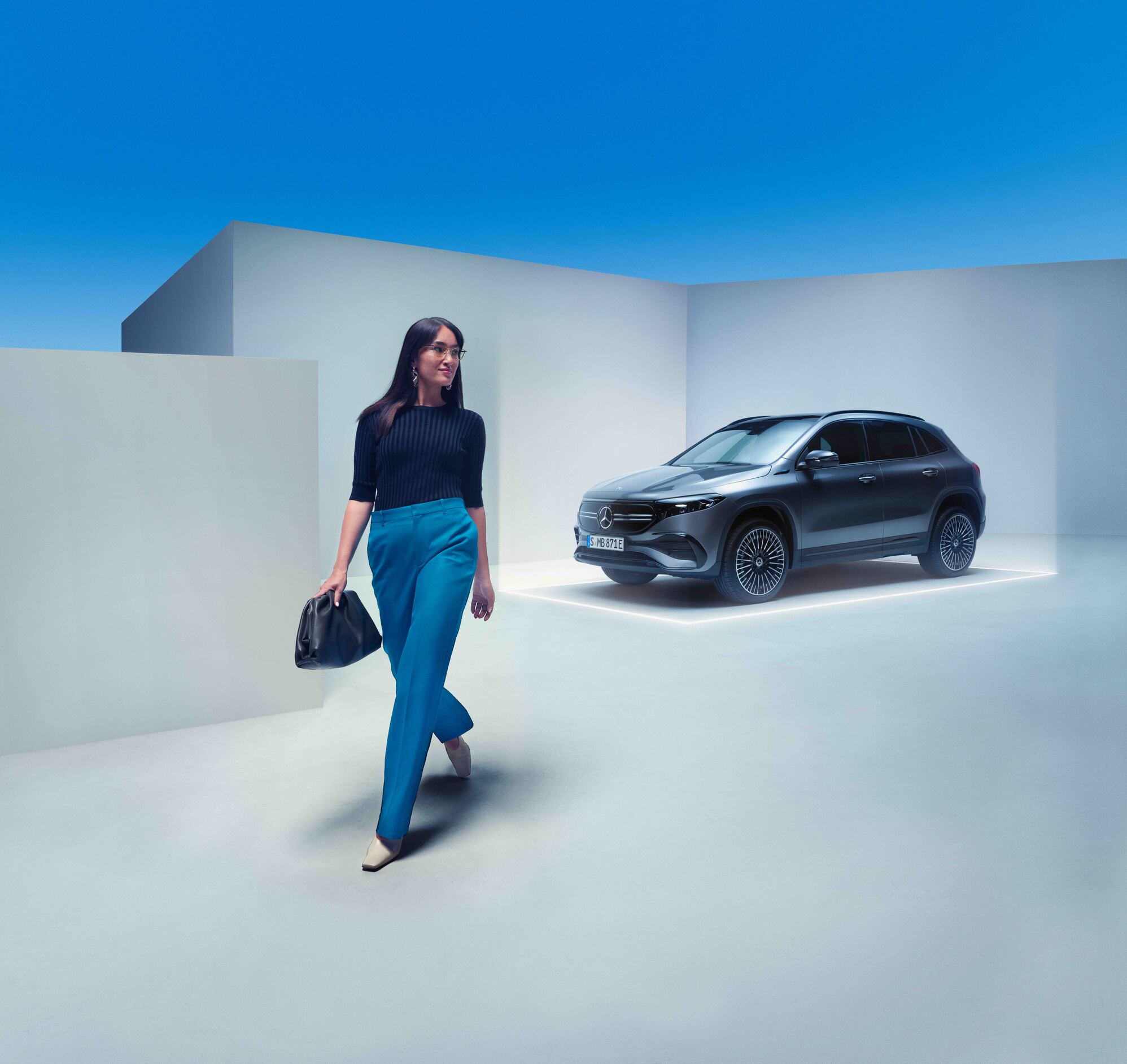 Prøvekørsel | Firmabil | Mercedes-Benz Kvinde med taske går væk fra sin parkerede Mercedes-Benz