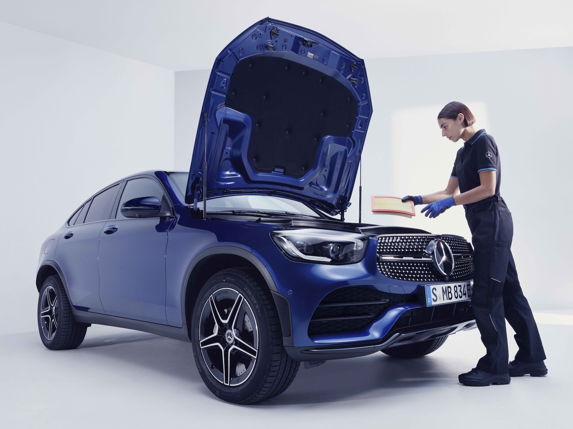 Mercedes-Benz tekniker inspicerer blå Mercedes-Benz bil