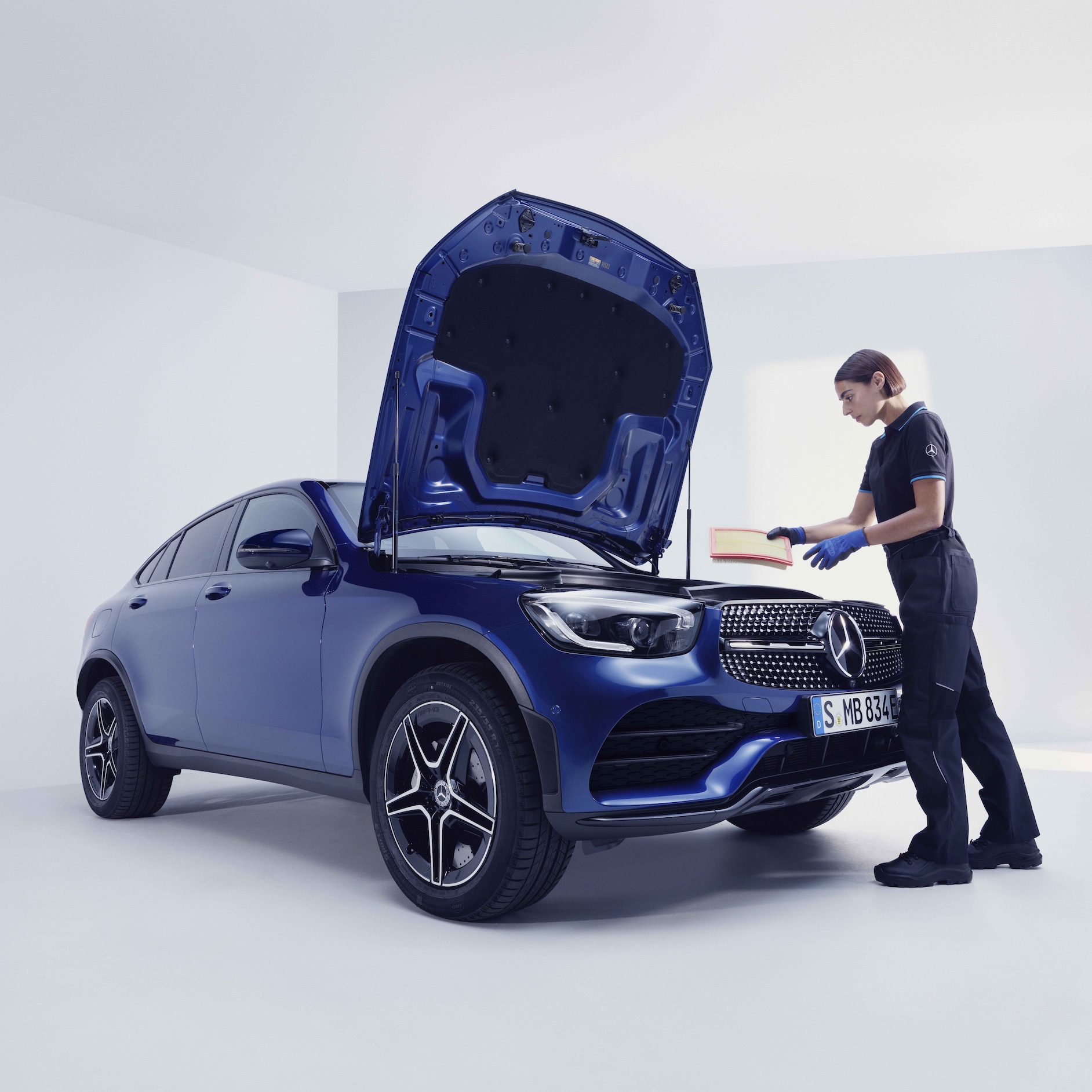 Regelmæssigt på prøvestand | Serviceeftersyn | Mercedes-Benz Mercedes-Benz tekniker inspicerer blå Mercedes-Benz bil