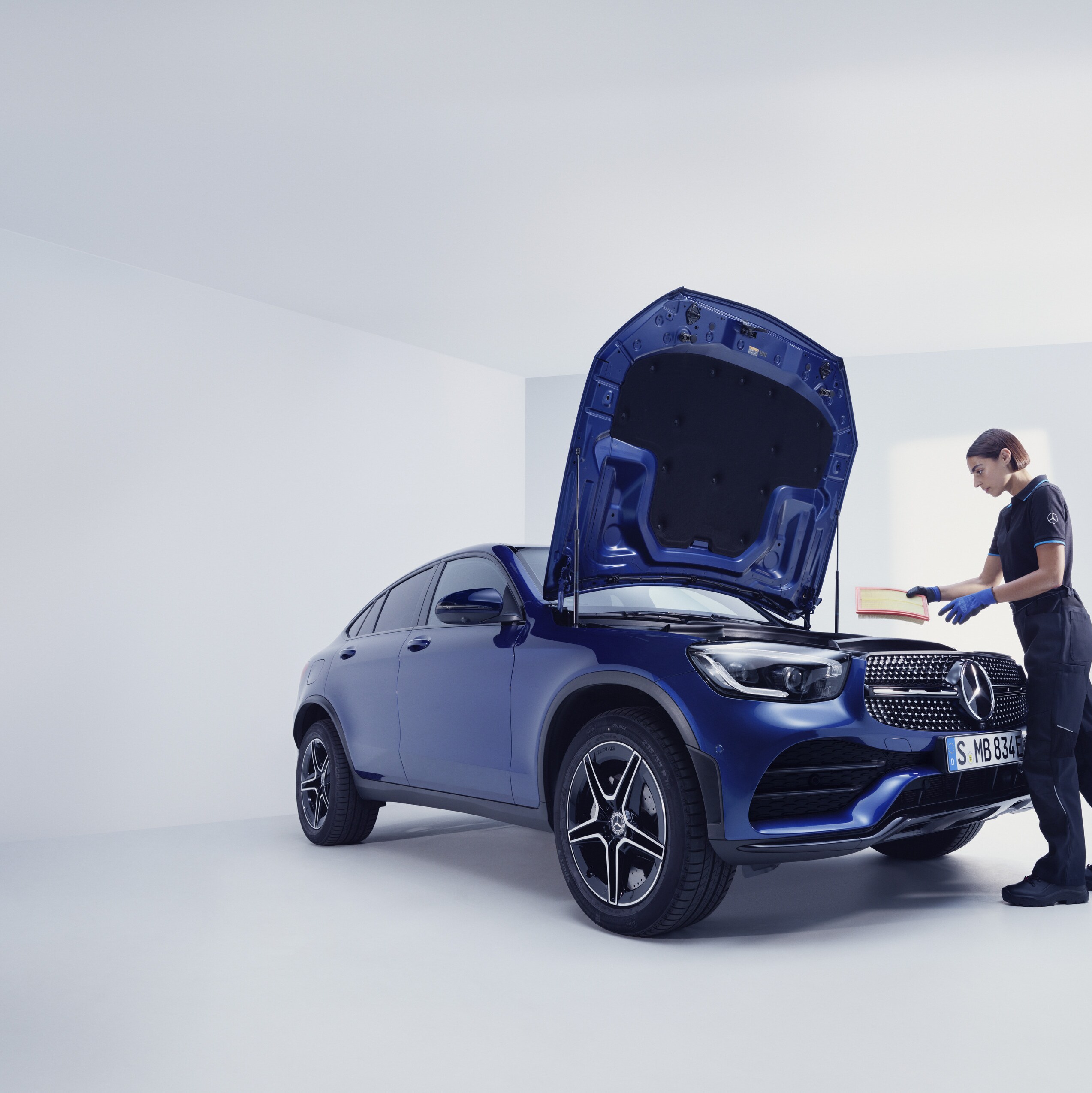 Mercedes-Benz mekaniker og kunde står ved åben motorhjelm på bil