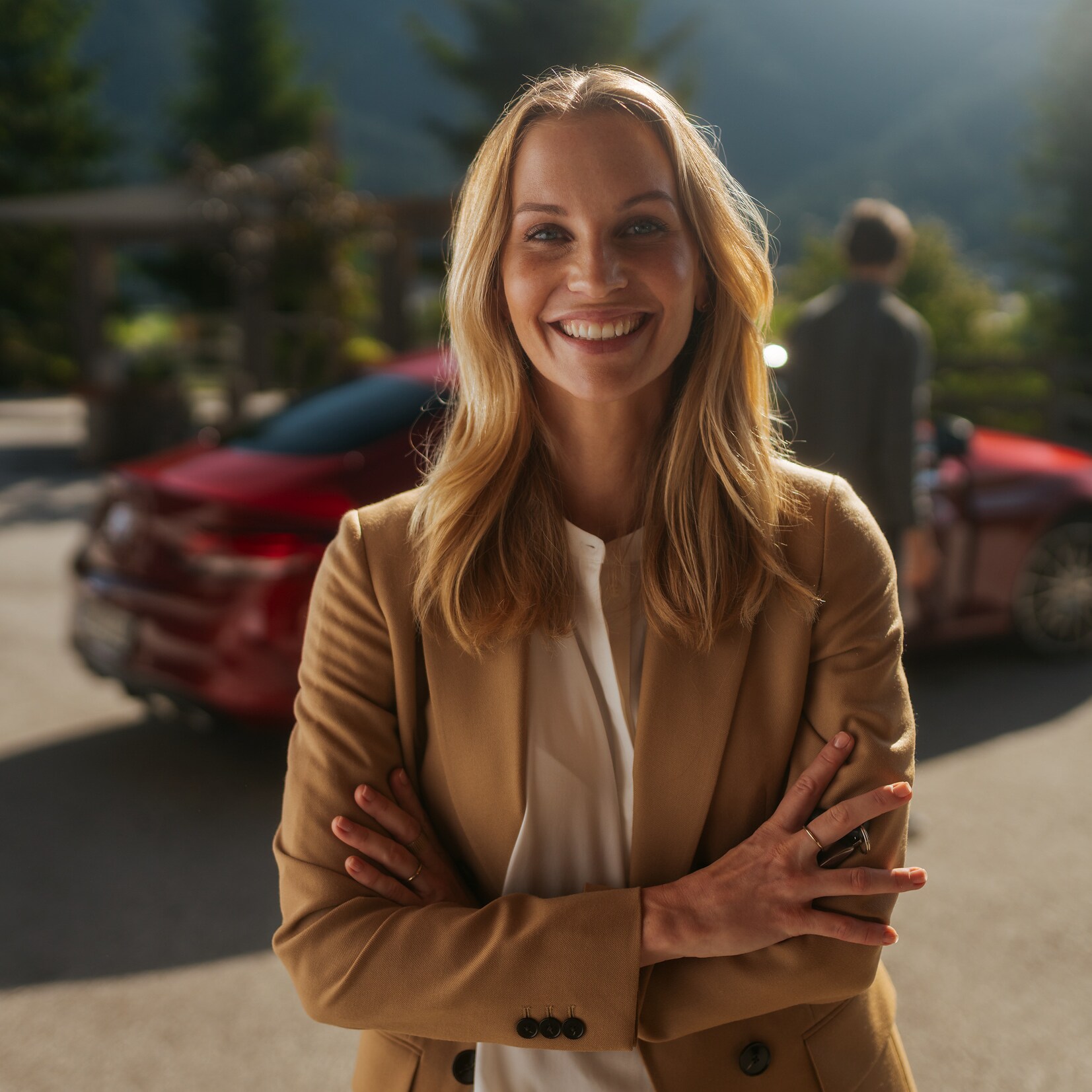 Kvinde står og smiler foran en Mercedes-Benz