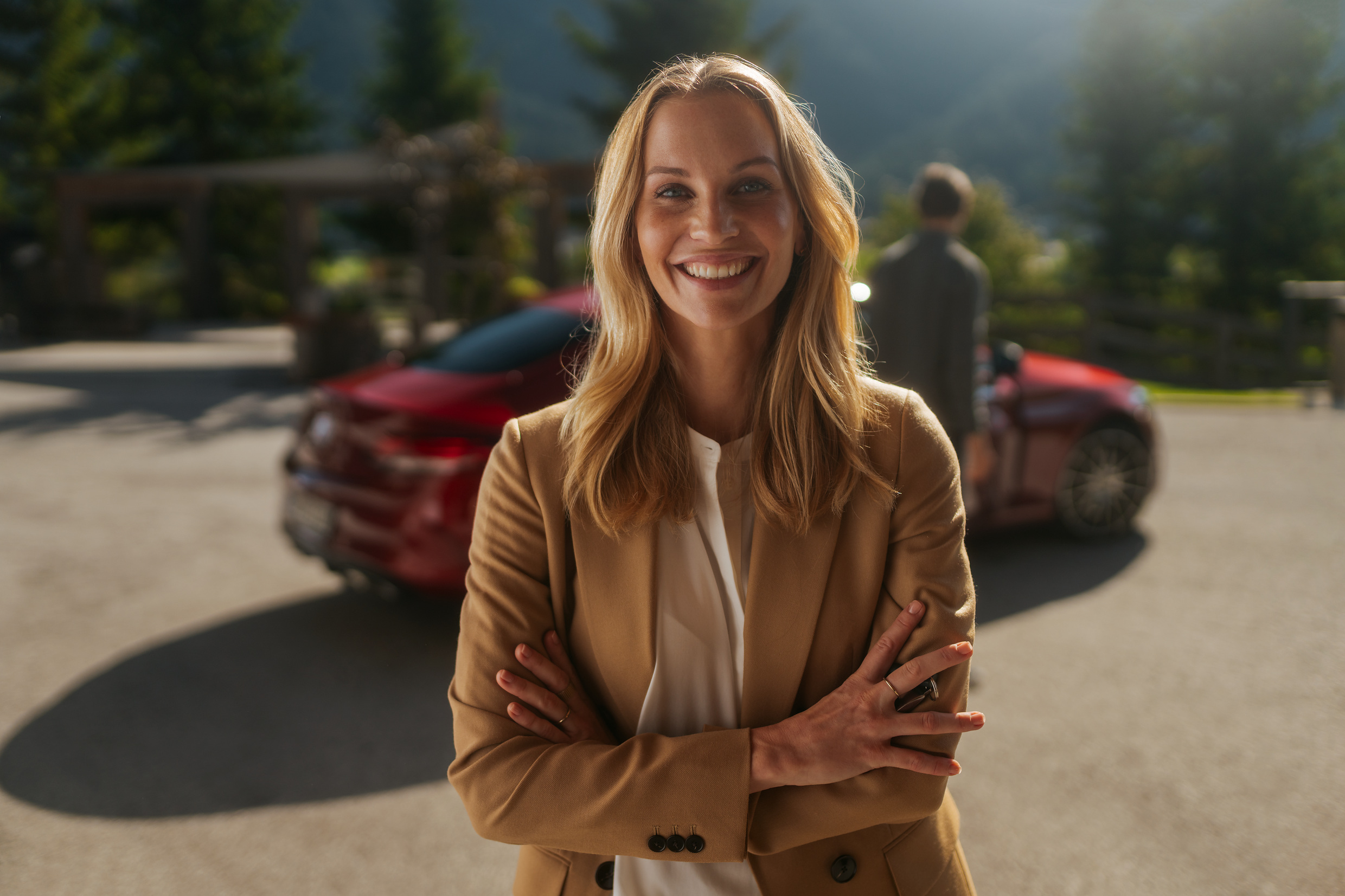 Betingelser for eksterne leverandører | Mercedes-Benz Kvinde står og smiler foran en Mercedes-Benz