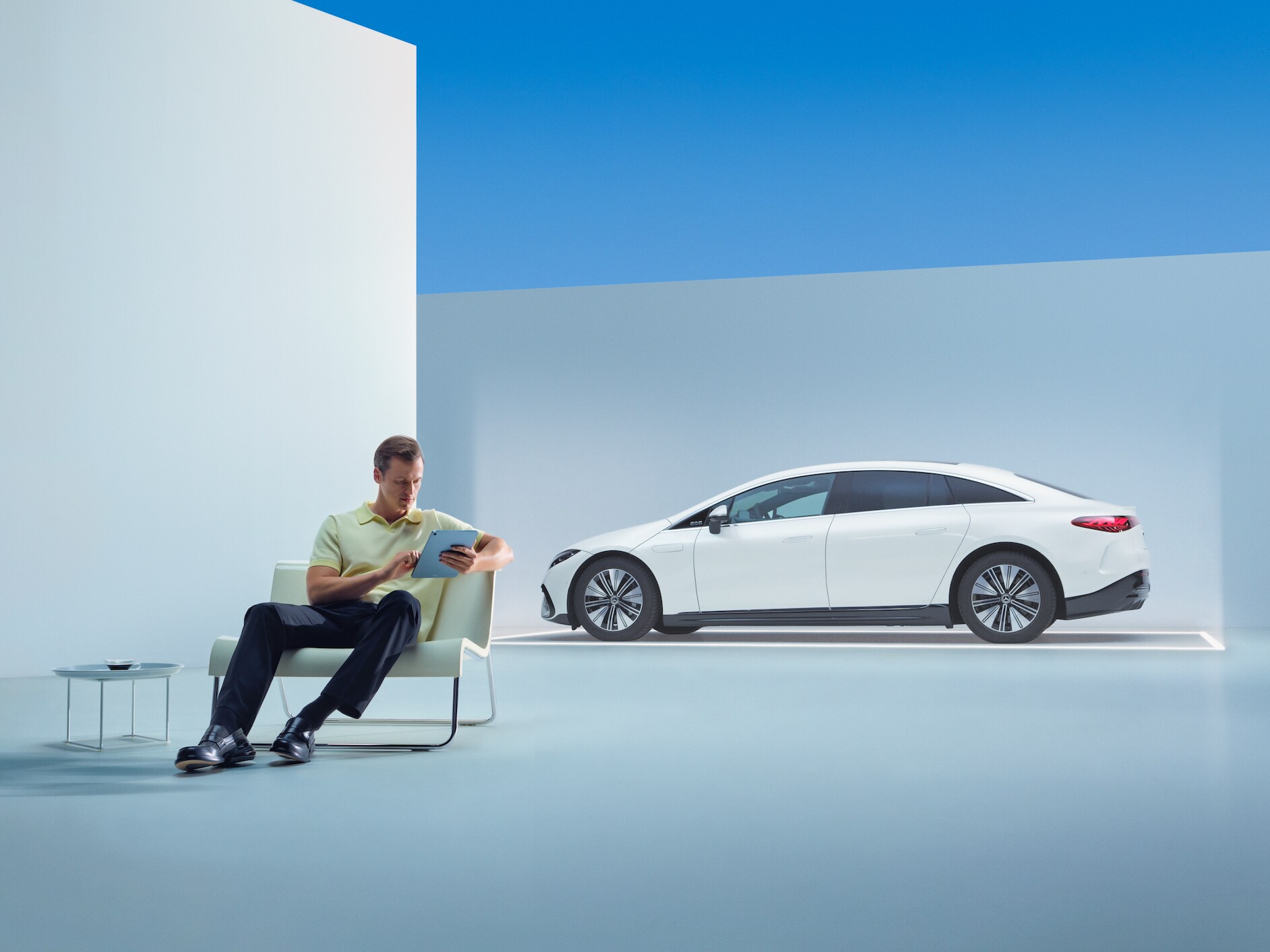 En person sidder foran sin Mercedes med sin tablet