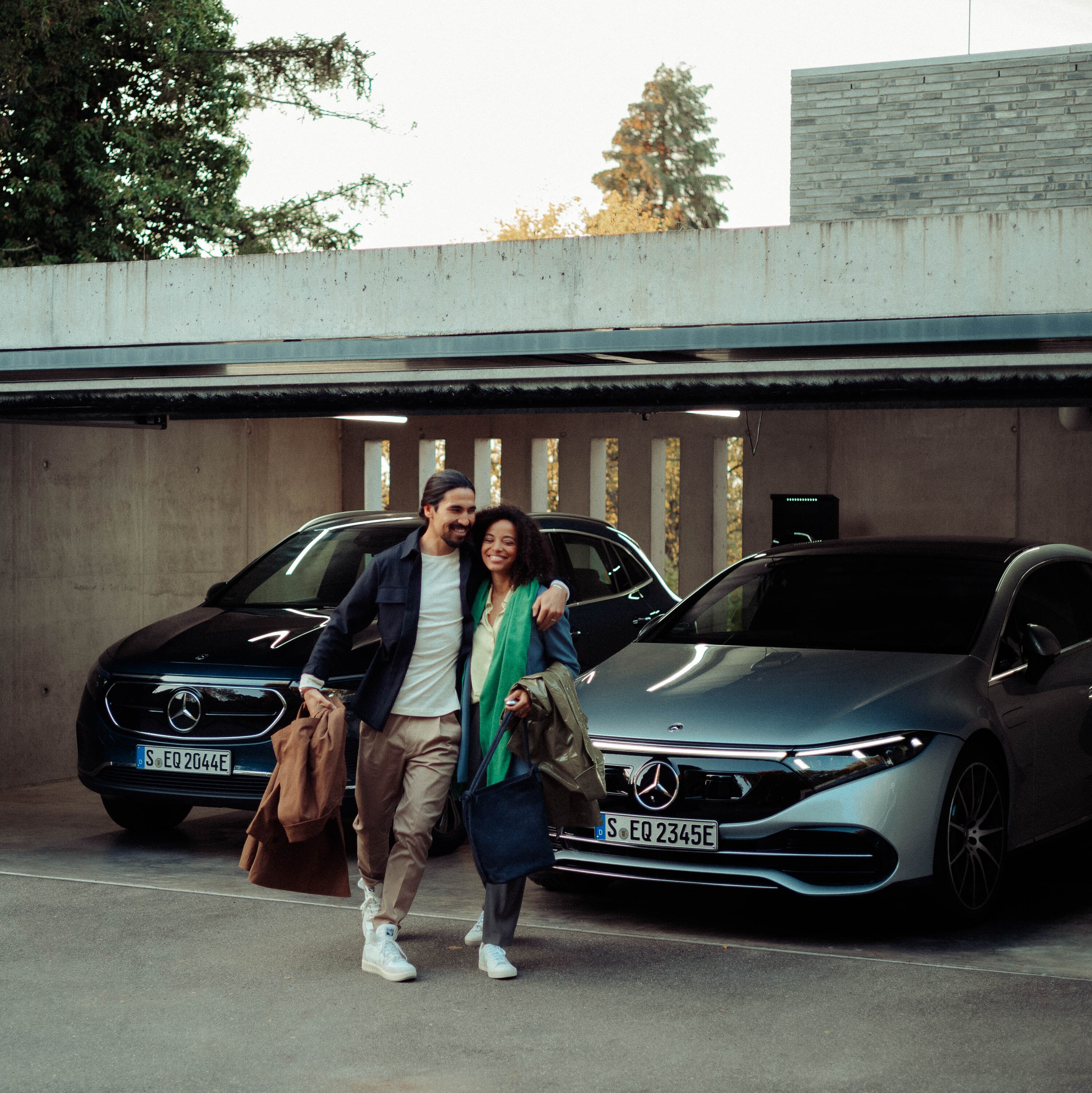 Mand og kvinde forlader garage, hvor EQS Sedan og EQA er parkeret