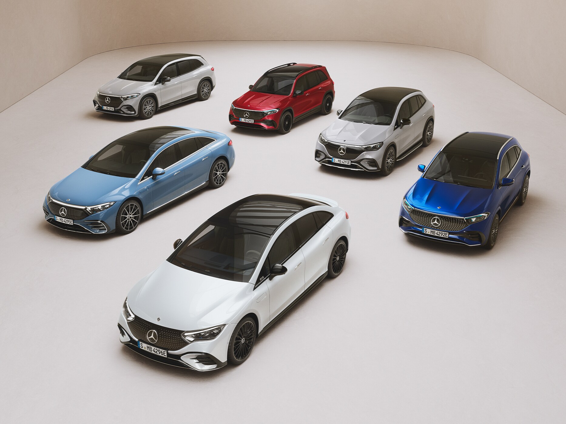 Forskellige Mercedes-Benz modeller parkeret side om side i et showroom.