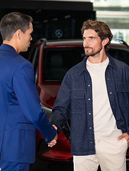 En mand hilser på en forhandler i et Mercedes-Benz showroom