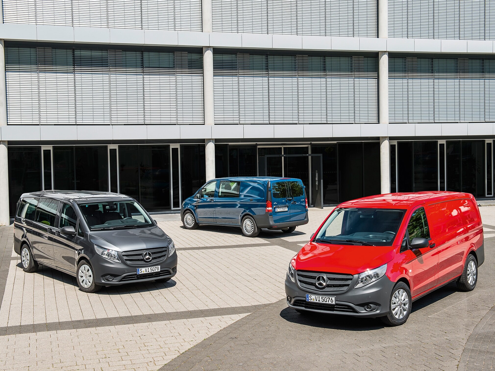 Tre Mercedes-Benz Vito parkeret foran en moderne kontorbygning