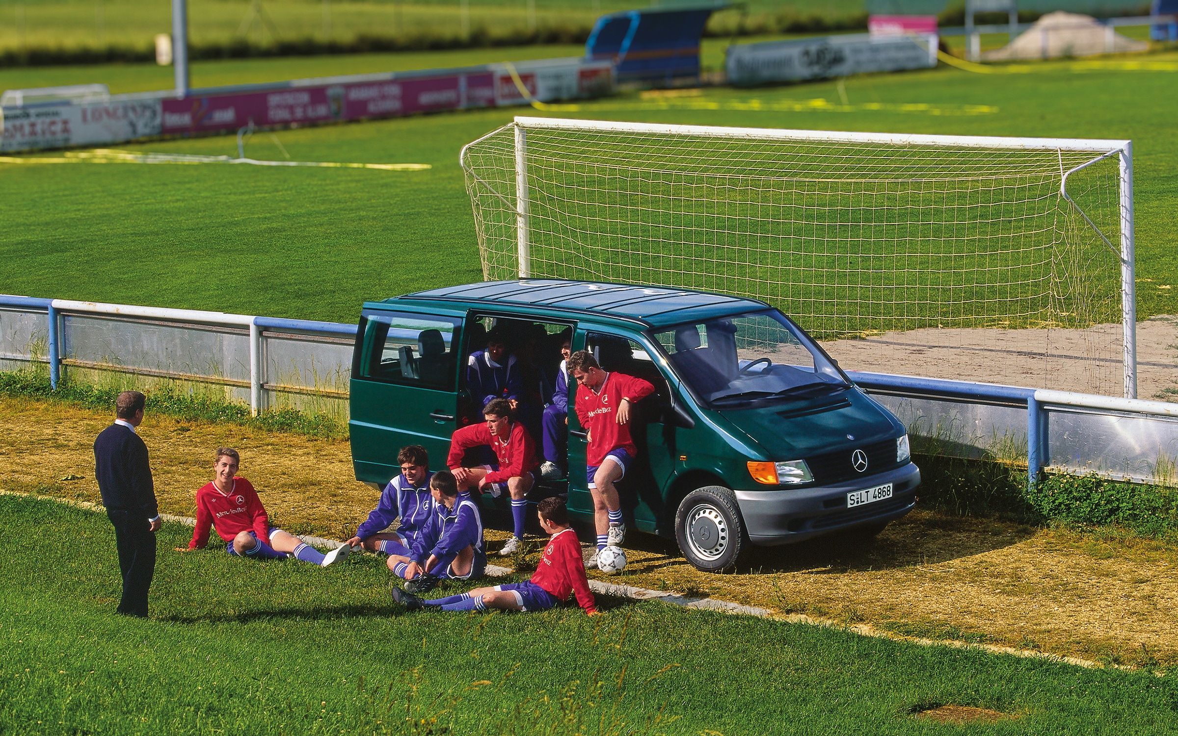 Mercedes-Benz Vito | Historien bag erhvervskøretøjerne | Mercedes-Benz Først generations Vito parkeret ved siden af en fodboldbane med fodboldspillere