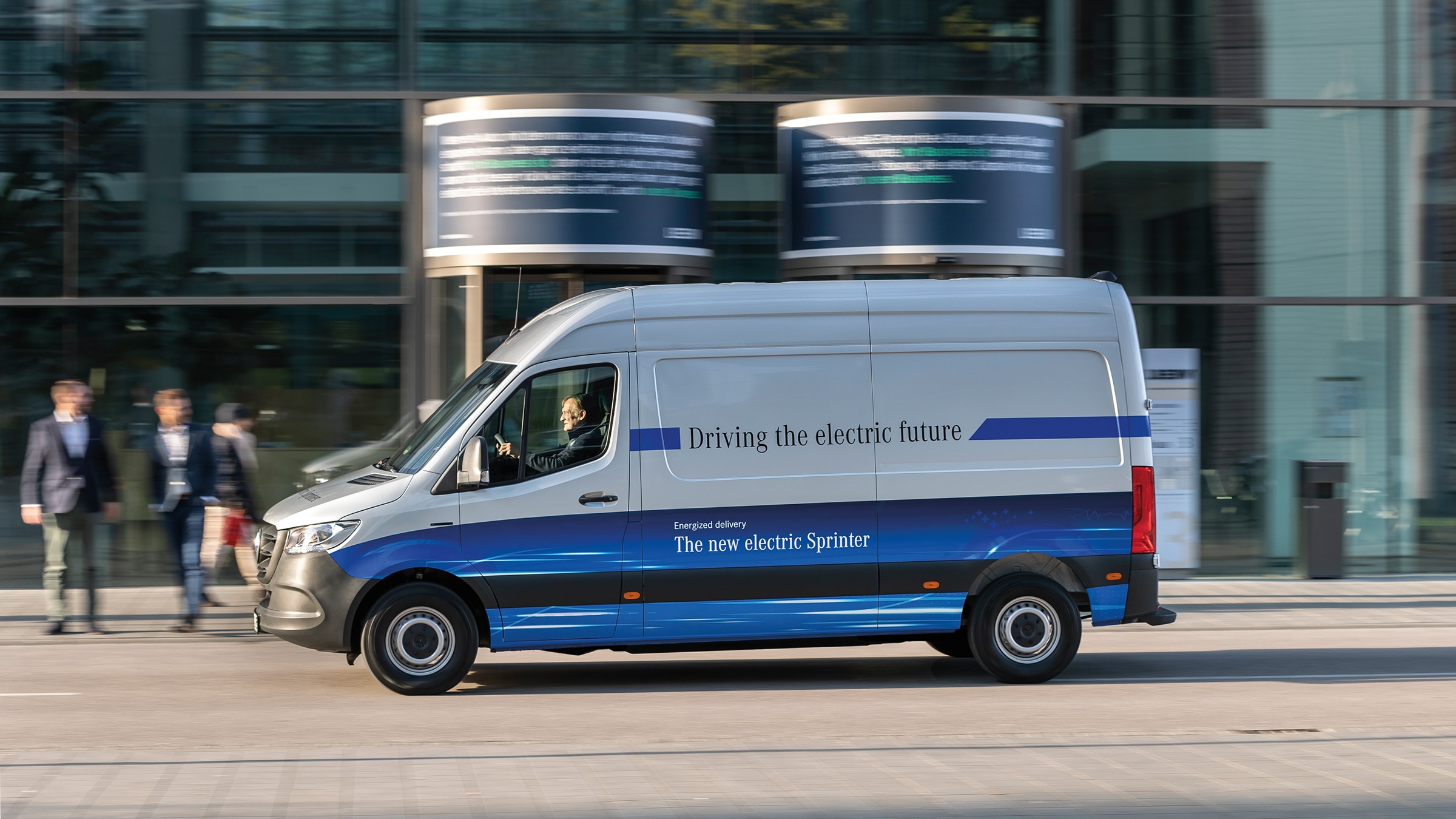 Anden generation eSprinter | Historien bag erhvervskøretøjerne | Mercedes-Benz Mercedes-Benz eSprinter Kassevogn der kører på gaden i en moderne by