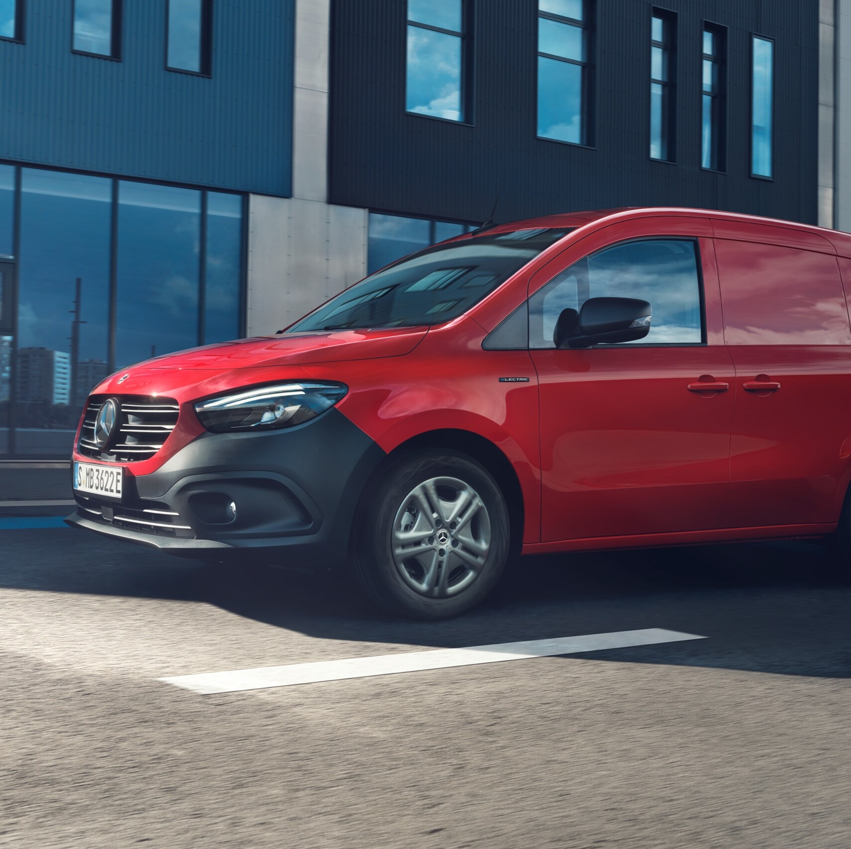 Rød Mercedes-Benz Citan parkeret på gaden foran butiksfacade