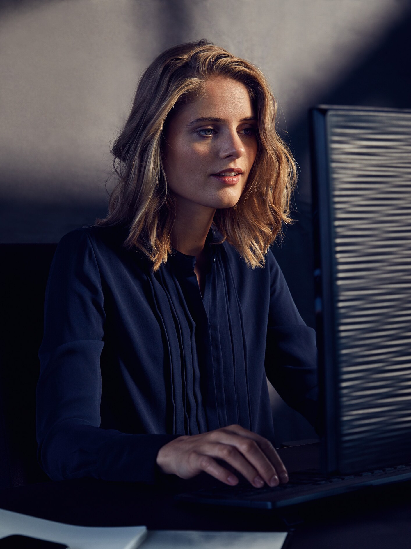 Kvinde sidder bag computerskærm