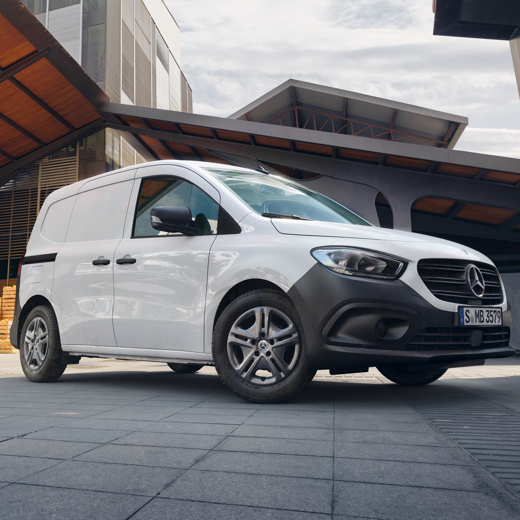 Hvid Mercedes-Benz Citan Kassevogn på p-plads foran kasser med frugt