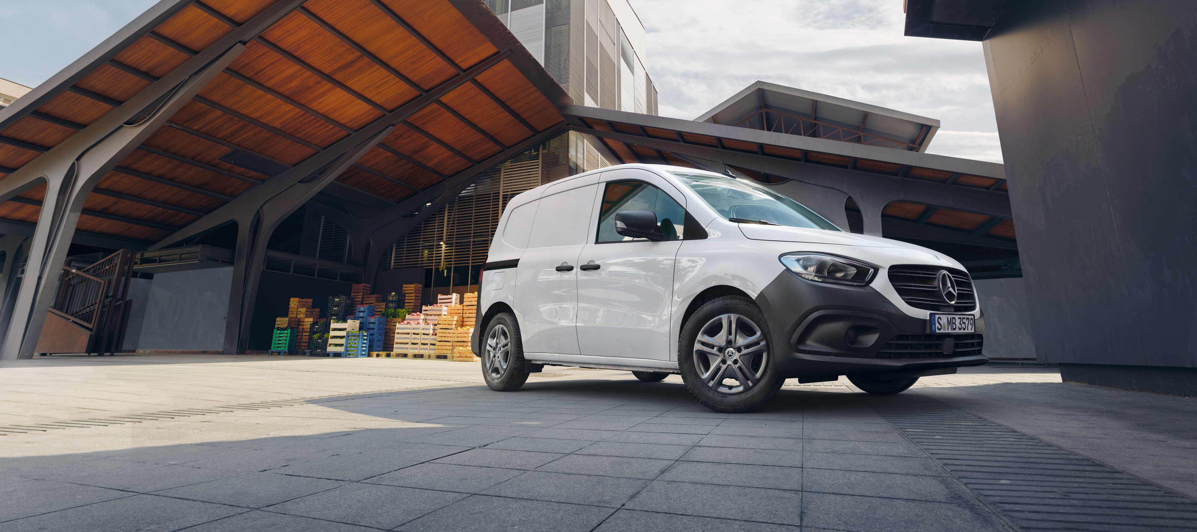 Mercedes-Benz Reorder | Mercedes-Benz Vans Hvid Mercedes-Benz Citan Kassevogn på p-plads foran kasser med frugt