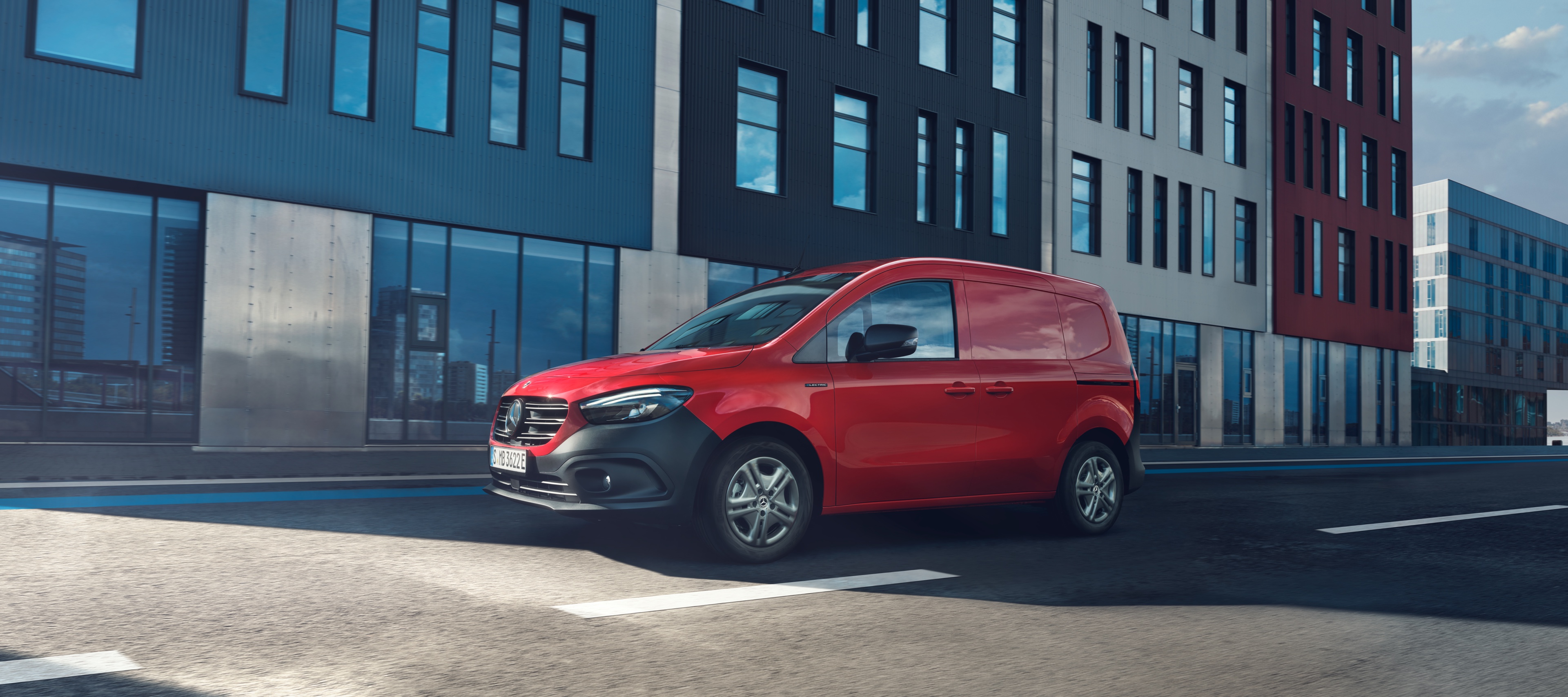 eCitan Kassevogn | Mercedes-Benz Vans Rød Mercedes-Benz eCitan Kassevogn parkeret på gaden foran butiksfacade.