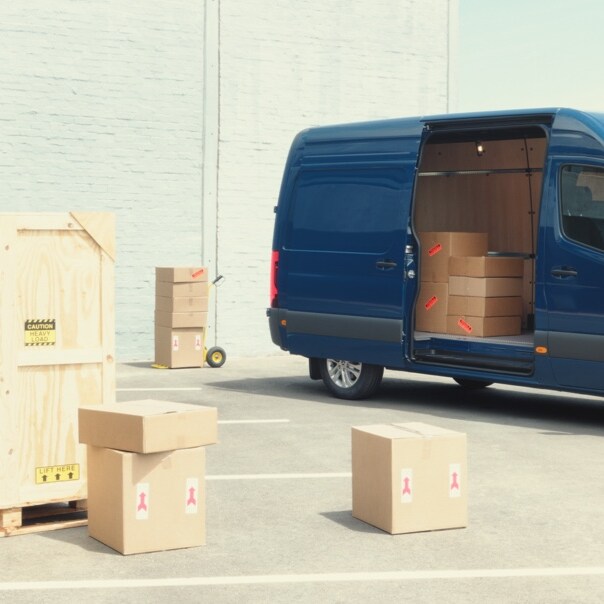 Blå Sprinter Kassevogn med åben sidedør og kig ind i lastrum med papkasser