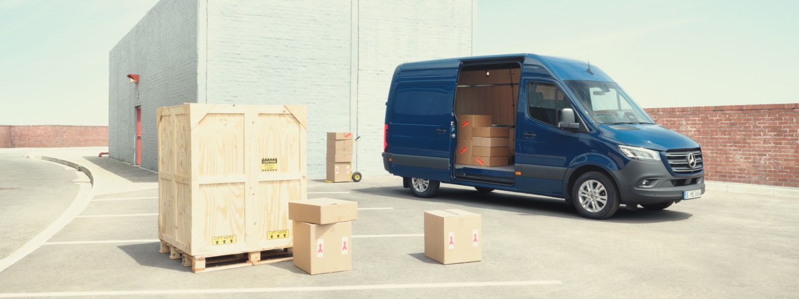 Mercedes-Benz Reorder | Mercedes-Benz Vans Blå Sprinter Kassevogn med åben sidedør og kig ind i lastrum med papkasser