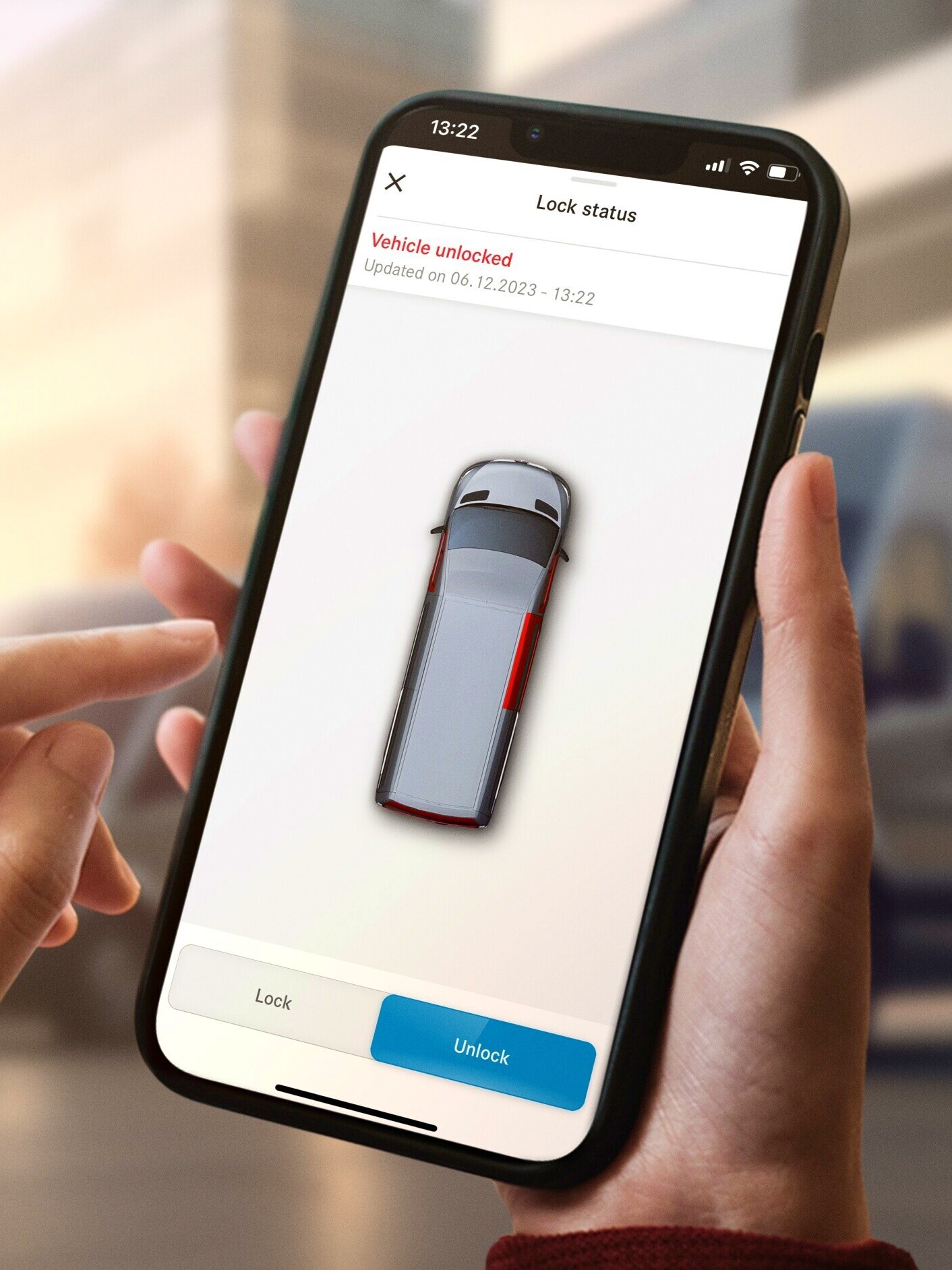Hånd med mobiltelefon og Mercedes-Benz app med digitale tjenester
