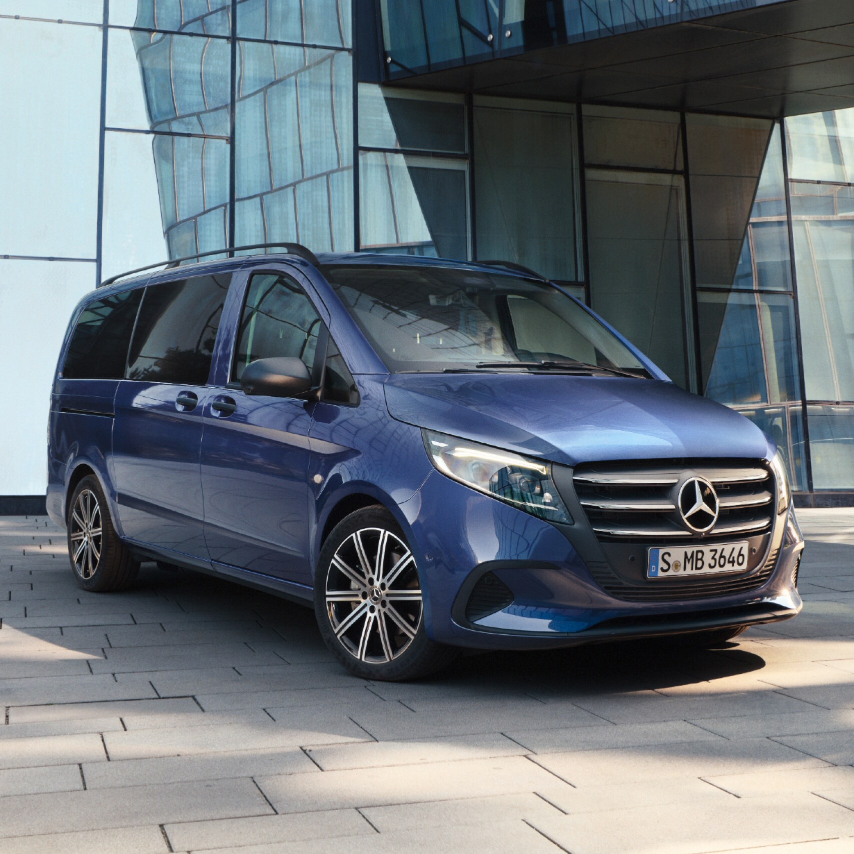Mørk blå Mercedes-Benz Vito Tourer parkeret foran indgang til kontorbygning