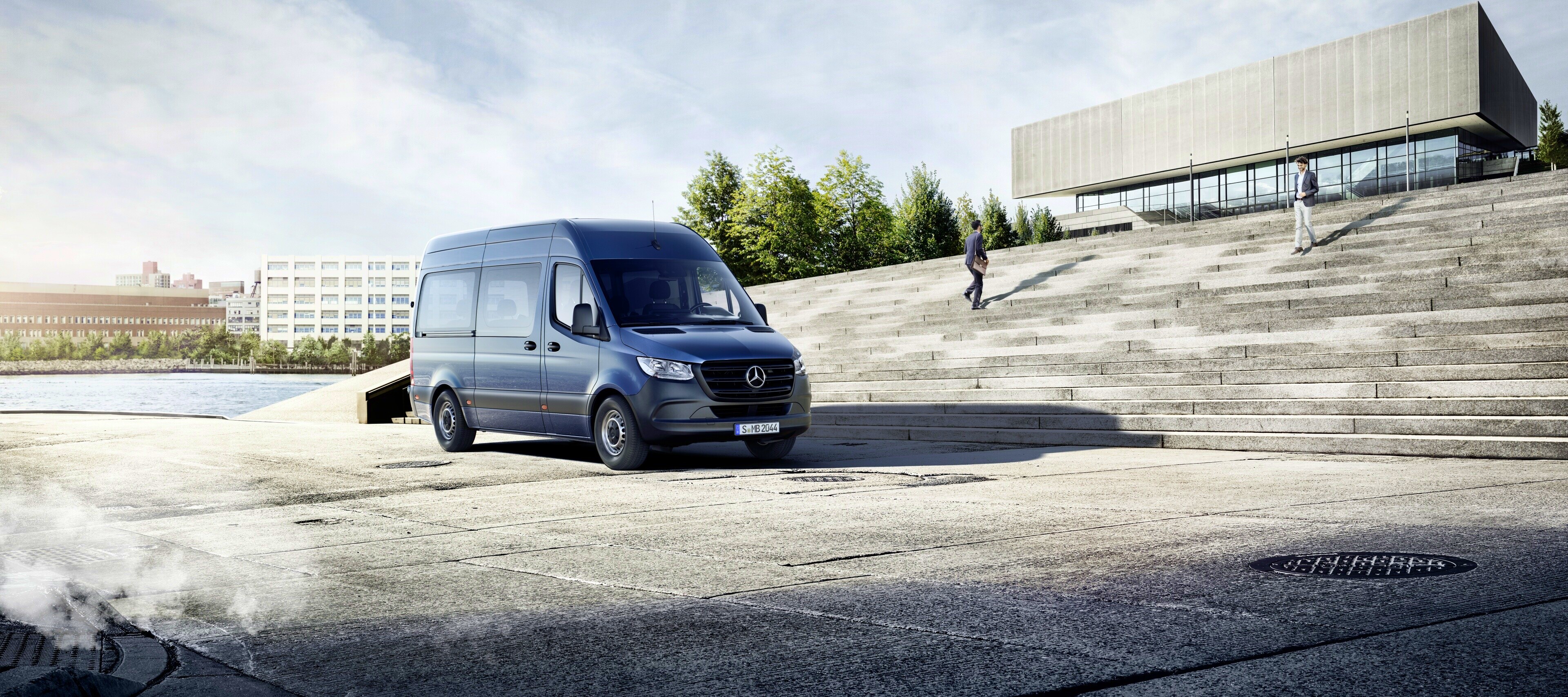 Bilsammenligning | Sprinter Tourer | Mercedes-Benz Vans Blå Mercedes-Benz Sprinter Tourer foran trappe op til en bygning