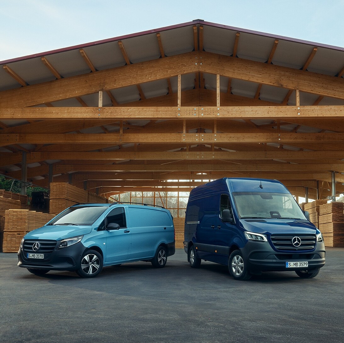 To Mercedes-Benz varebiler ude foran en trælast.