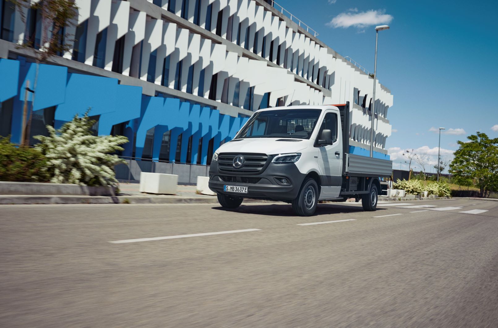 eSprinter Chassis | Leasing og finansiering Mercedes-Benz eSprinter Chassis som ladvogn kører forbi kontorbygning