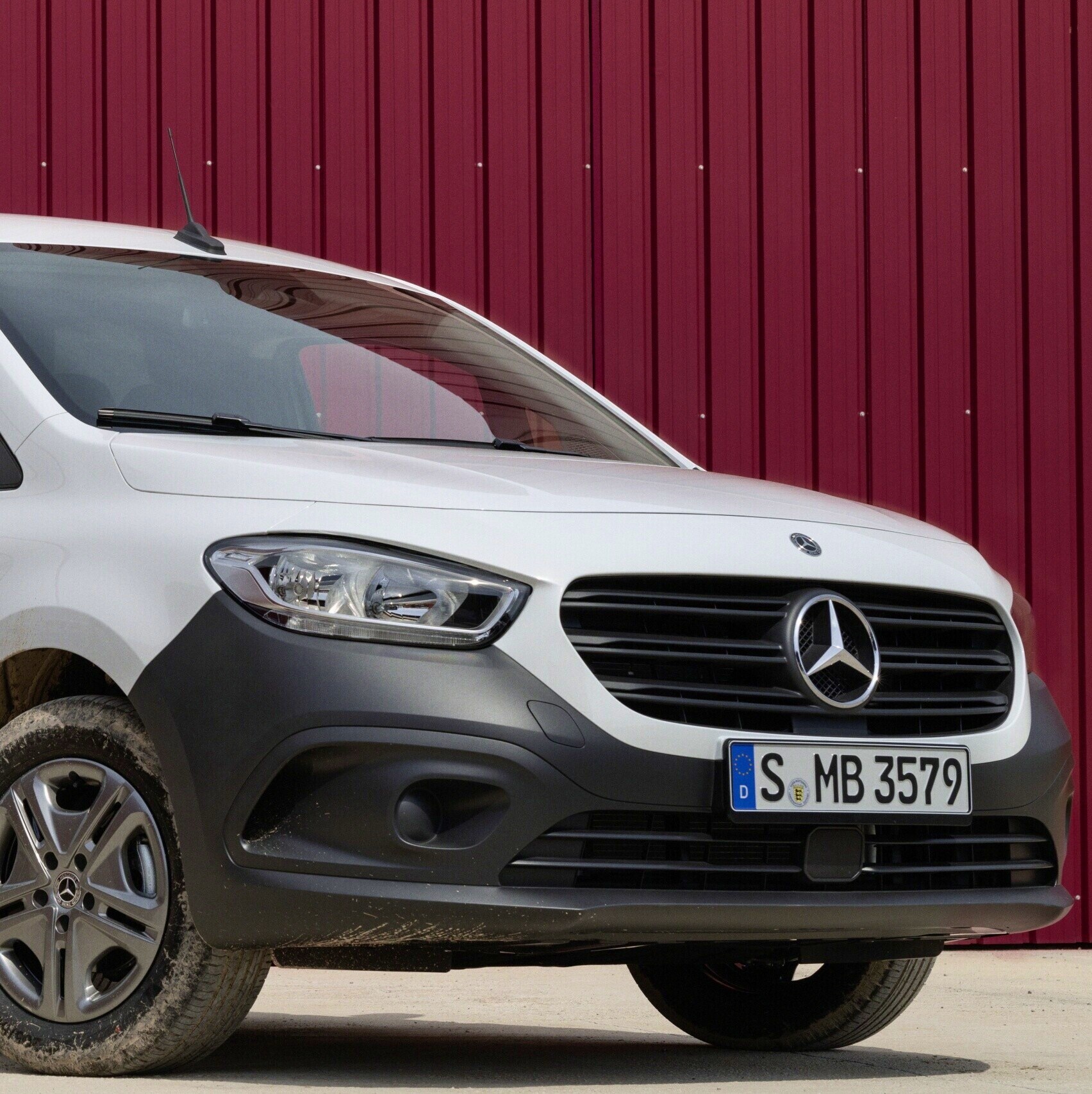Hvid Mercedes-Benz Citan Kassevogn parkeret foran rød lagerbygning