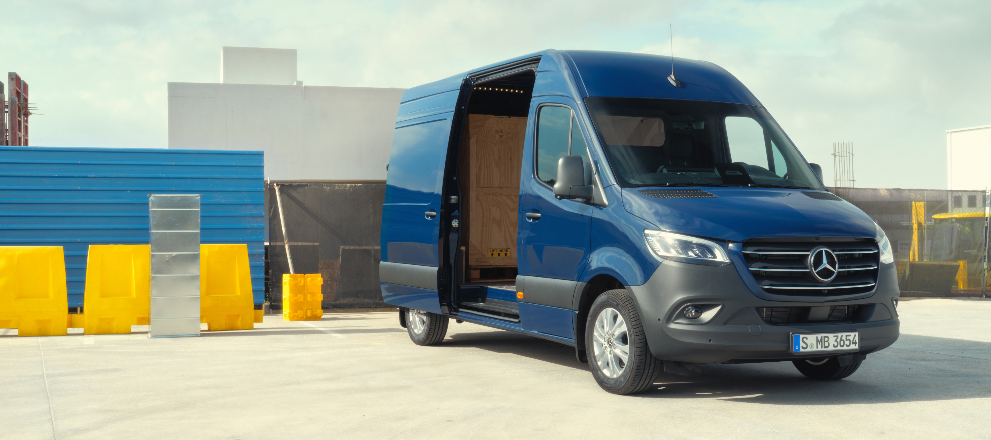 Bilsammenligning | Sprinter Kassevogn | Mercedes-Benz Vans Mercedes-Benz Sprinter Kassevogn med åben sidedør på byggeplads
