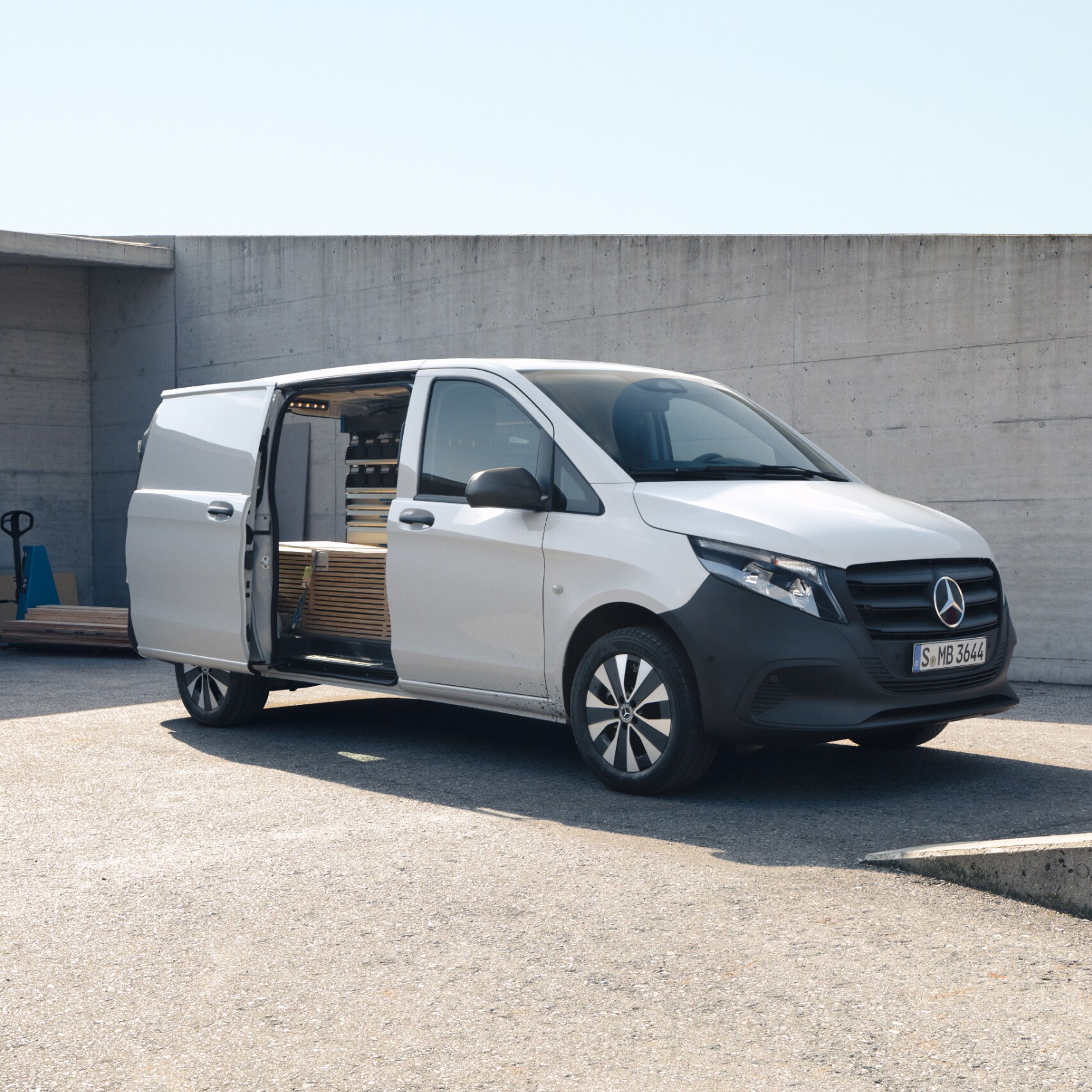 Hvid Mercedes-Benz Vito Kassevogn med åben skydedør på en byggeplads