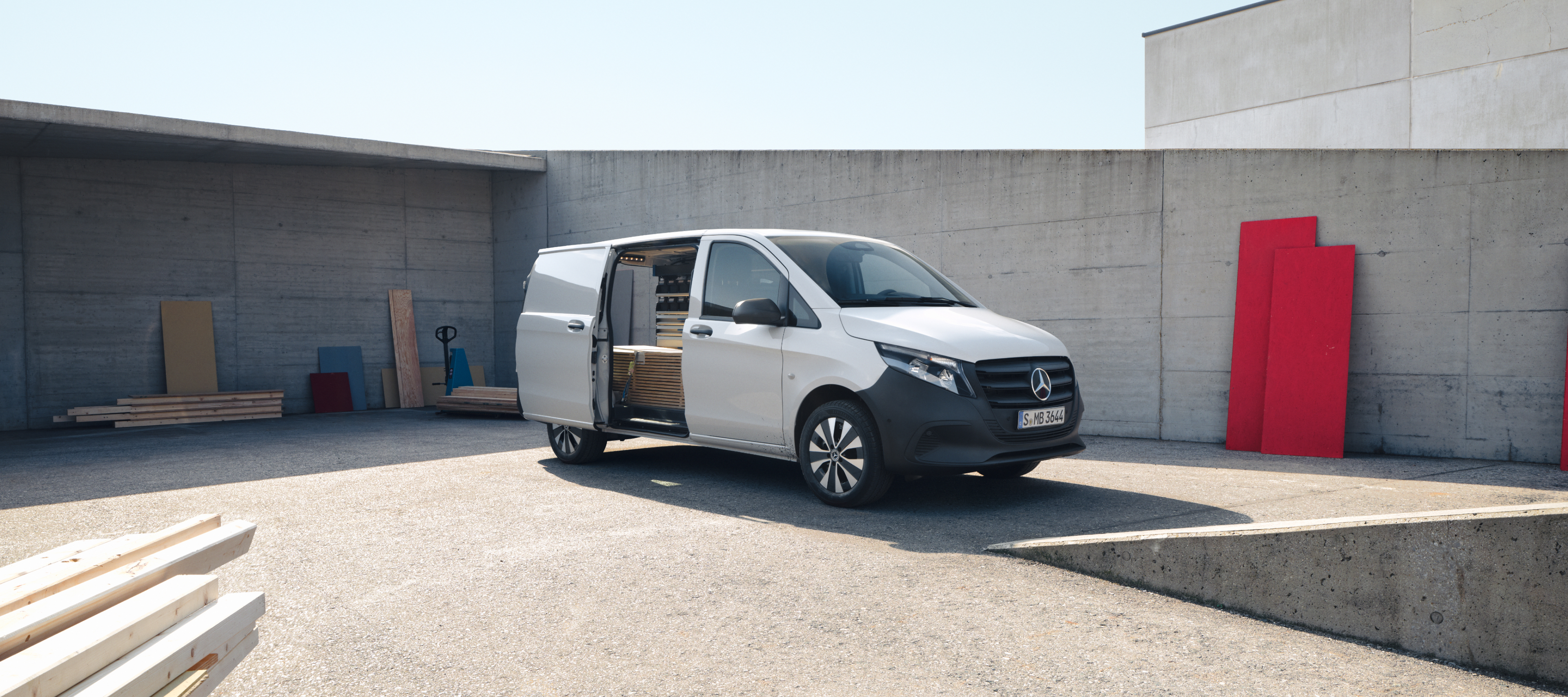 Bilsammenligning | Vito Kassevogn | Mercedes-Benz Vans Hvid Mercedes-Benz Vito Kassevogn med åben skydedør på en byggeplads