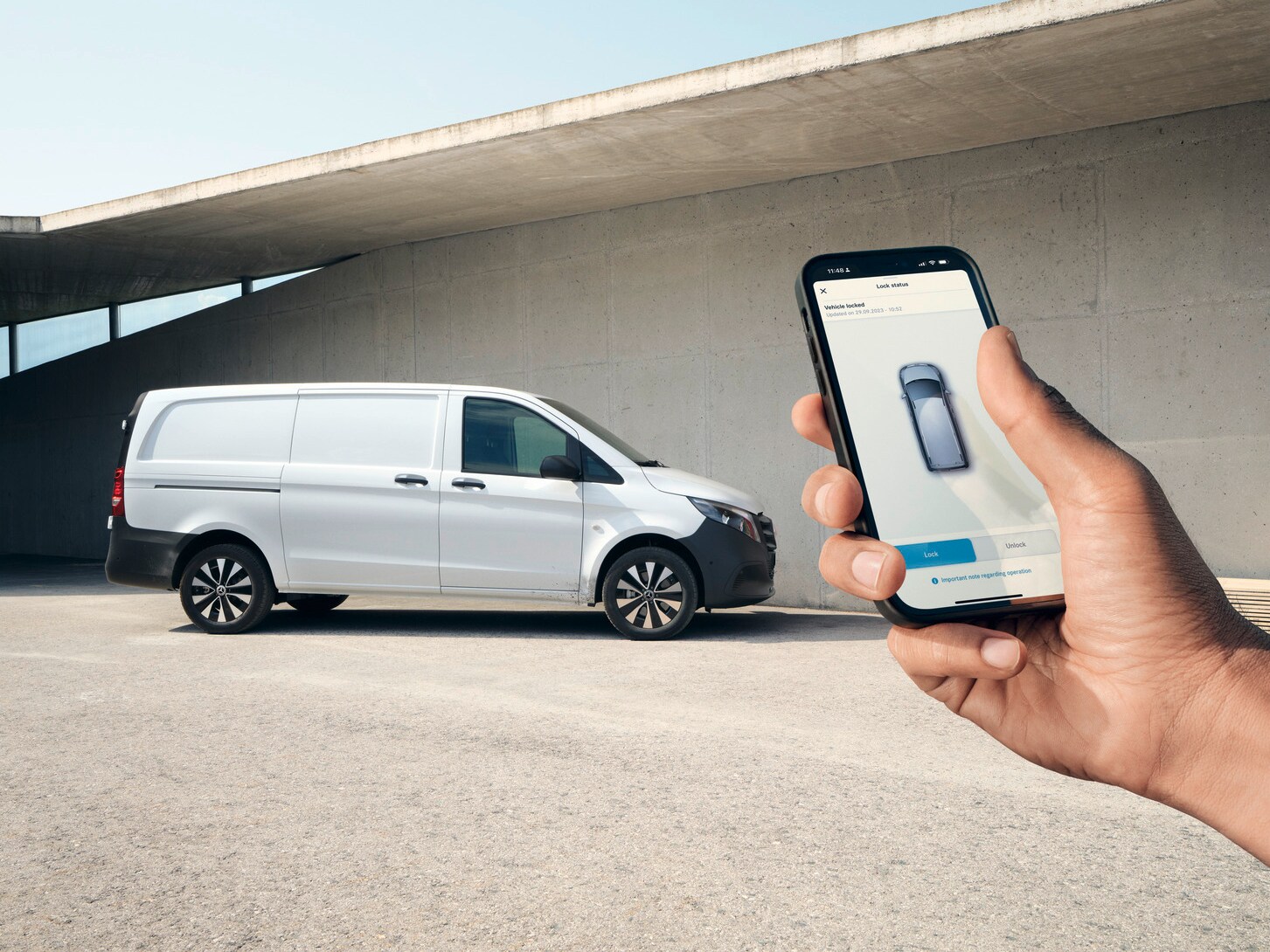 En hånd holder en smartphone, der viser Mercedes-Benz appen.