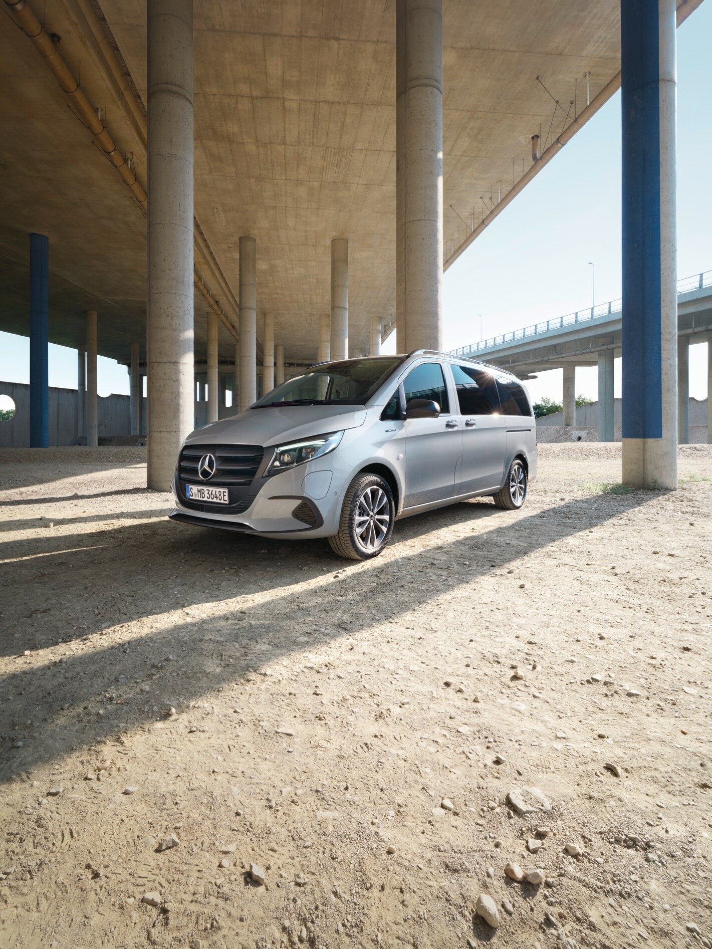 En lys grå metallic eVito Tourer holder parkeret under en bro