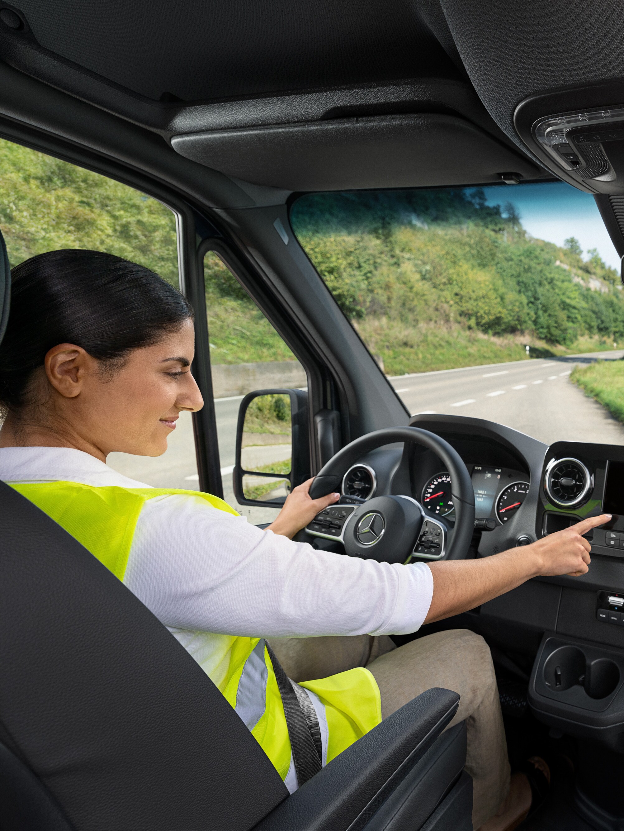 Chaufføren i en Mercedes-Benz Sprinter ringer til Mercedes-Benz Service24h-hotline via menuen i bilen, hvis hun har et problem.