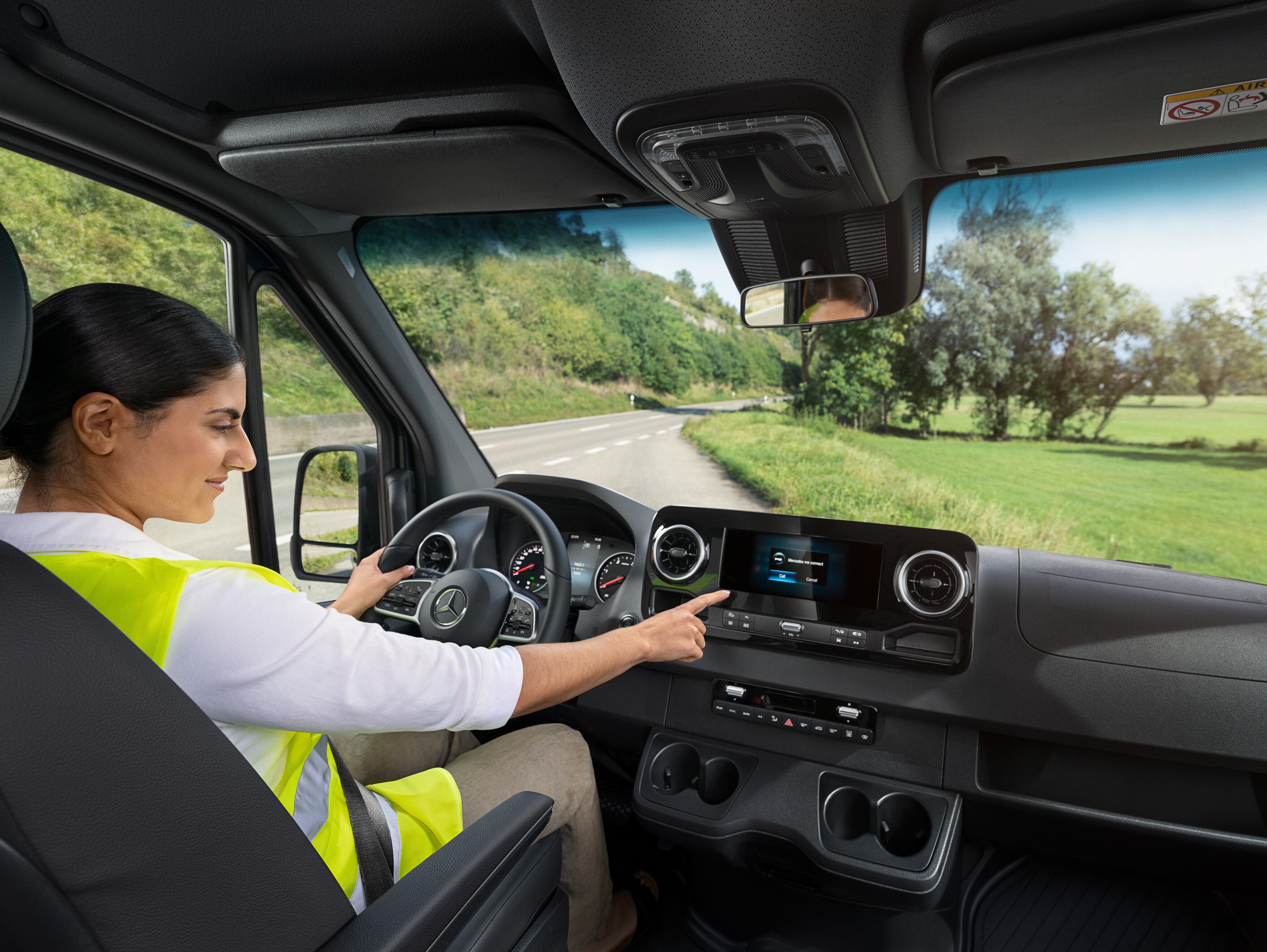 Chaufføren i en Mercedes-Benz Sprinter ringer til Mercedes-Benz Service24h-hotline via menuen i bilen, hvis hun har et problem.