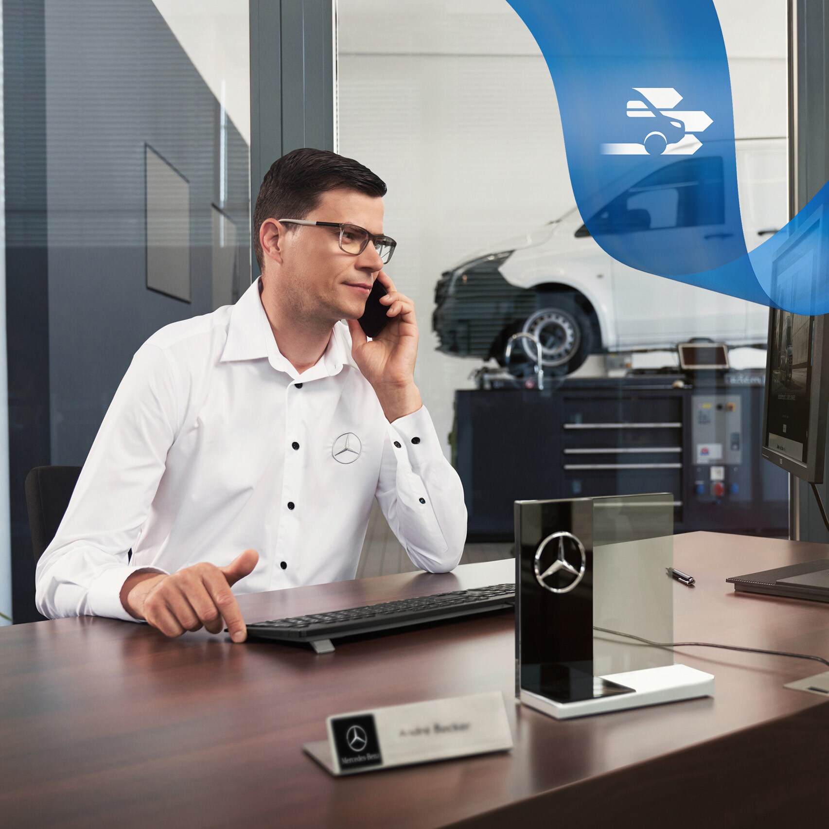Mercedes-Benz medarbejder taler i telefon, og i baggrunden ses en Mercedes-Benz Vito Varebil på værkstedet.
