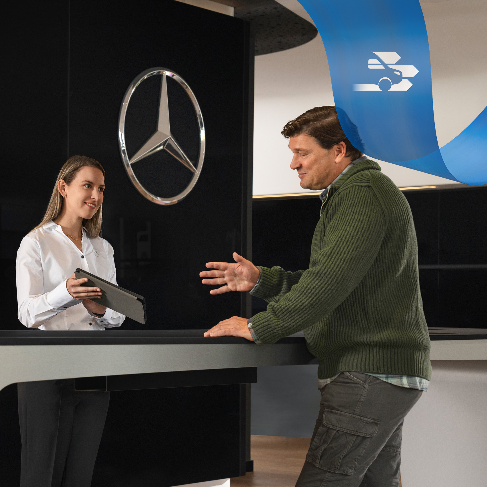 Mercedes-Benz | Varebilspleje | Individuel support En medarbejder fra Mercedes-Benz giver support til en kunde, mens han står ved en receptionsdisk.