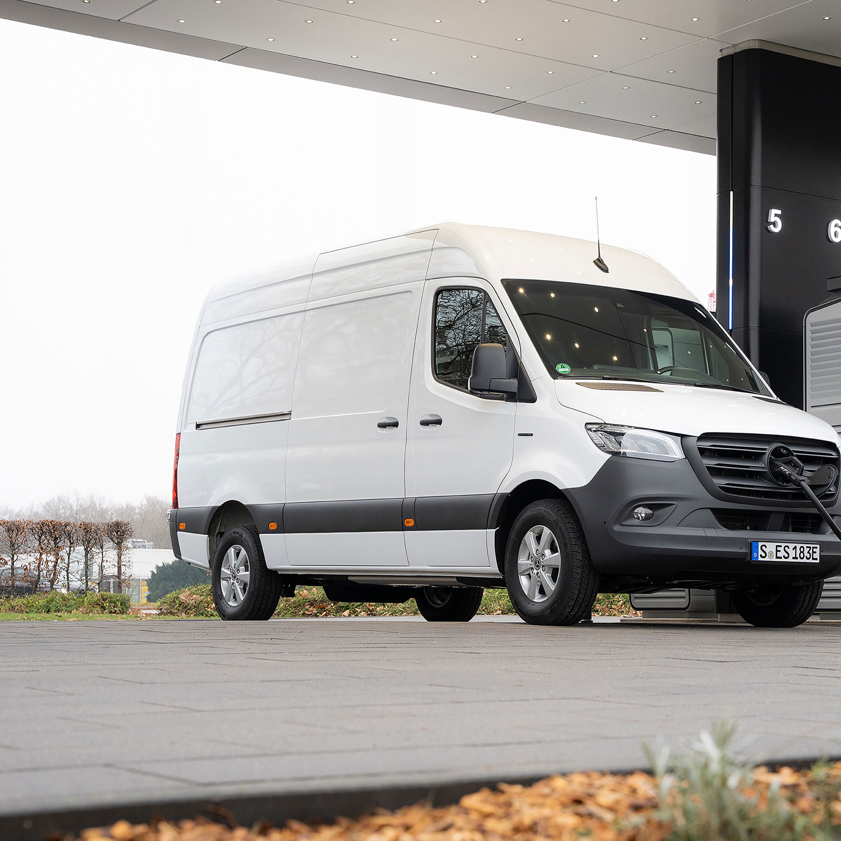 En Mercedes-Benz varebil foran en ladestation under opladning.