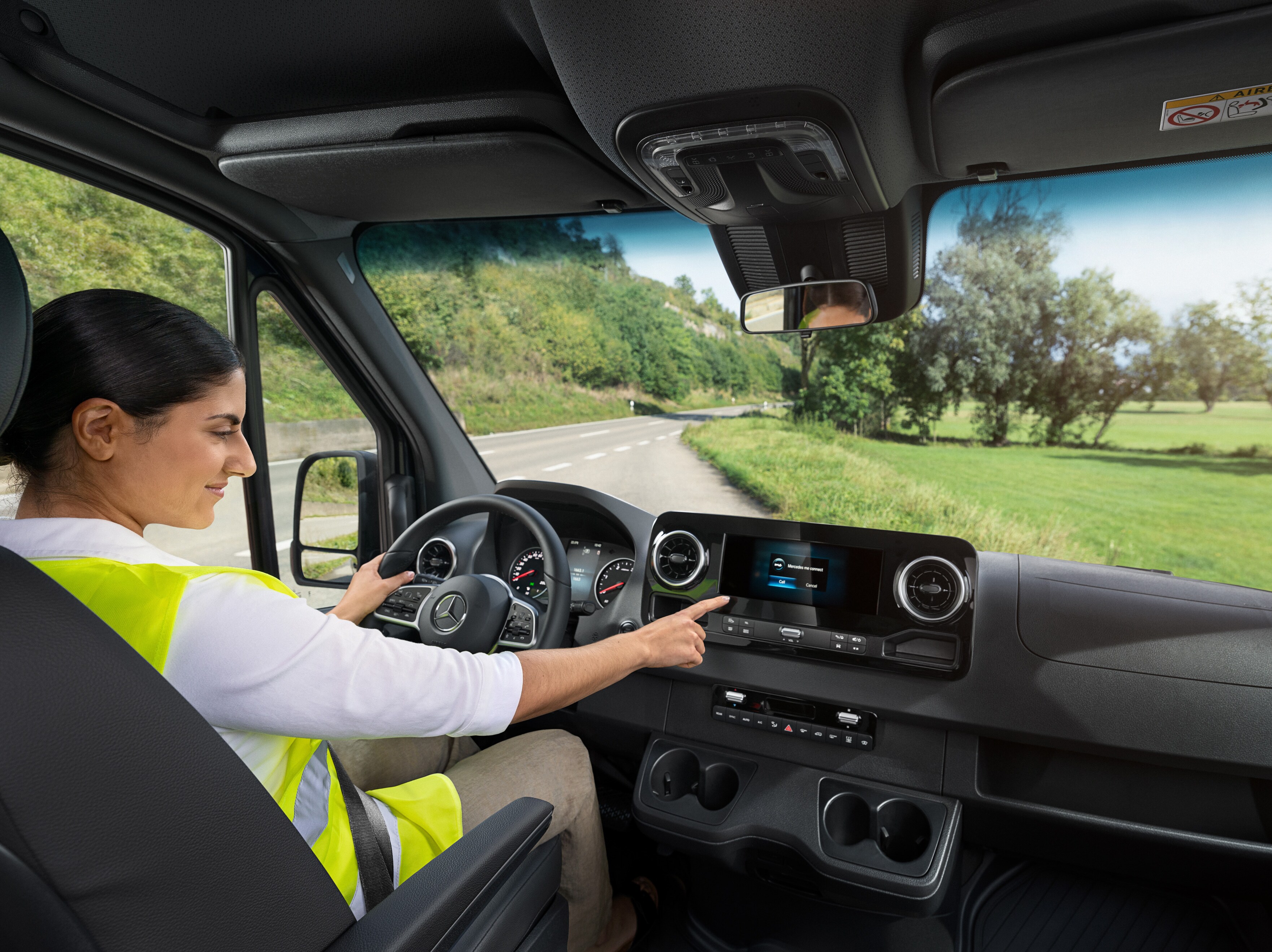 Chauffør tjekker det indbyggede display i sin Mercedes-Benz varebil.