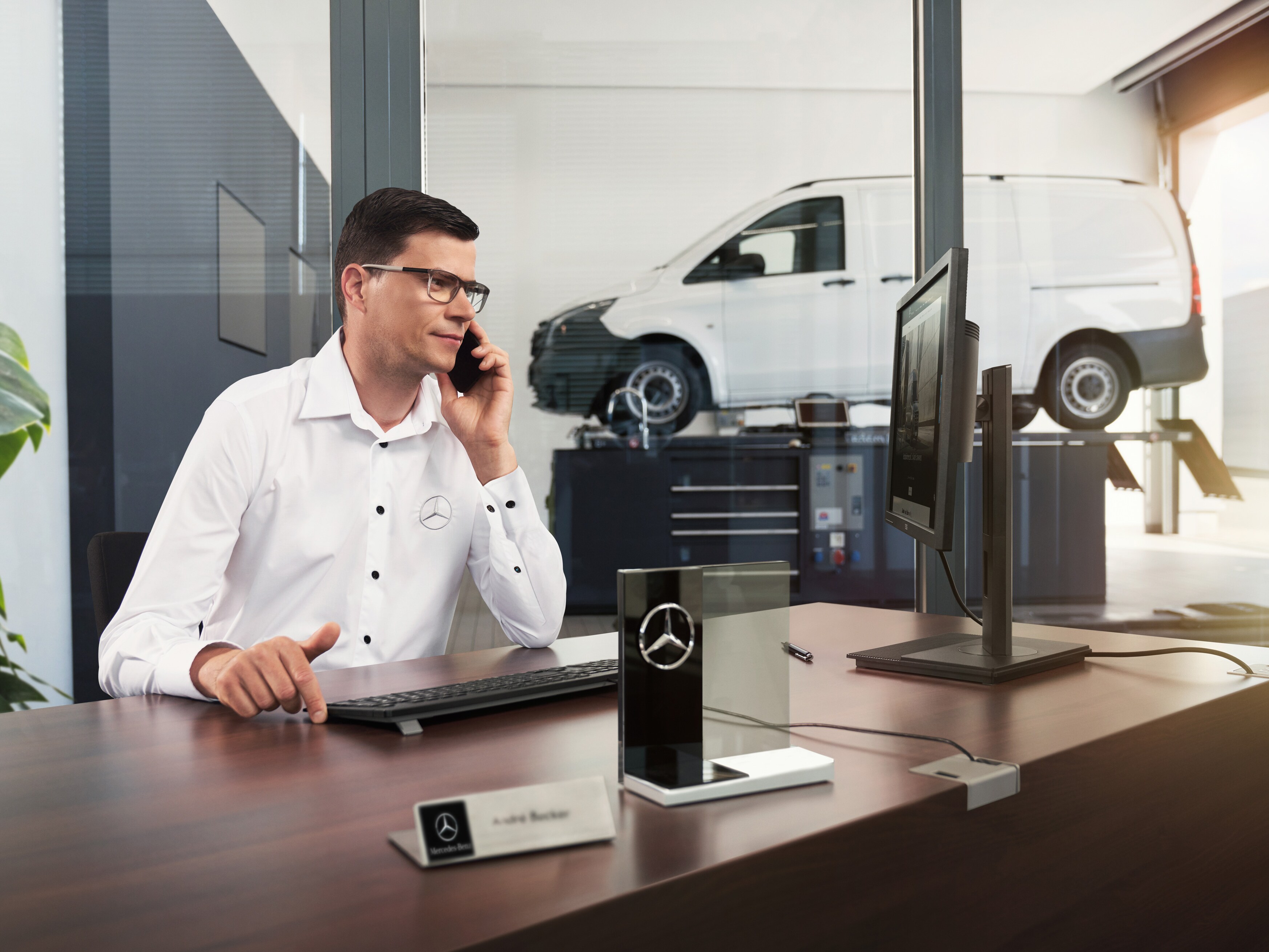 Mercedes-Benz servicerådgiver taler i telefon på et værksted.