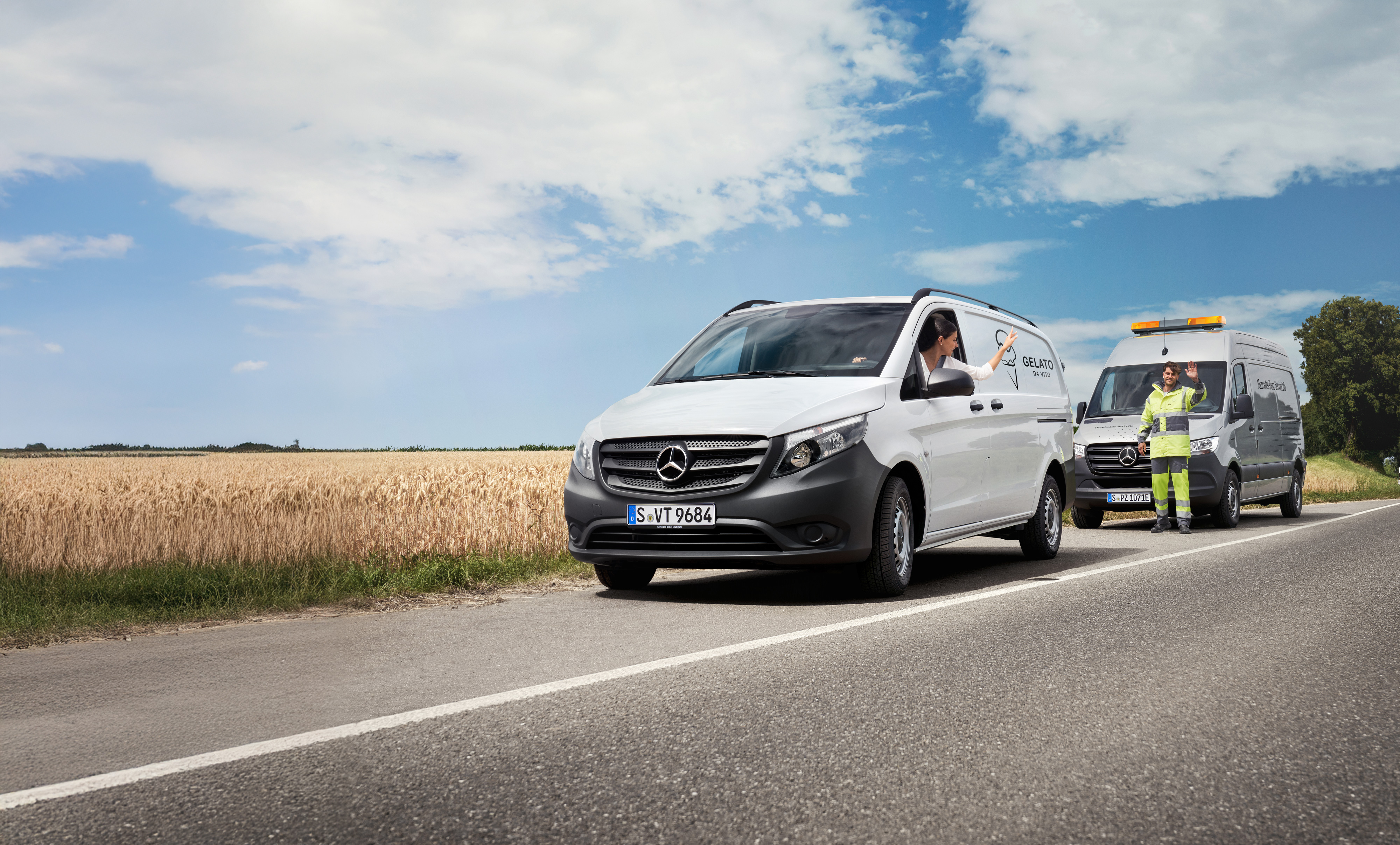 Mercedes-Benz | Mobilitetsløsninger | MobiloVan En kvinde, der sidder i en hvid Vito, vinker til en Mercedes-Benz servicetekniker i vejkanten.