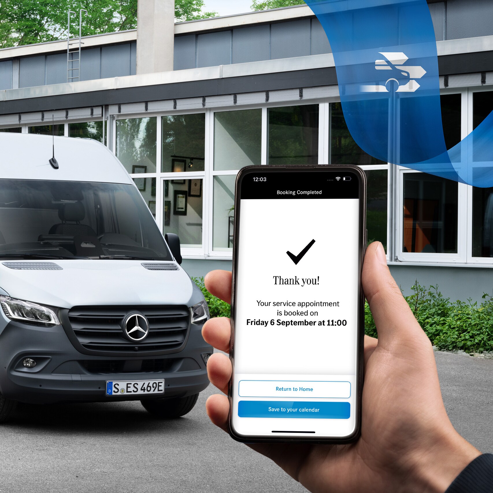 En grå Mercedes-Benz Sprinter varebil foran en kontorbygning med en hånd, der holder en smartphone, i forgrunden.