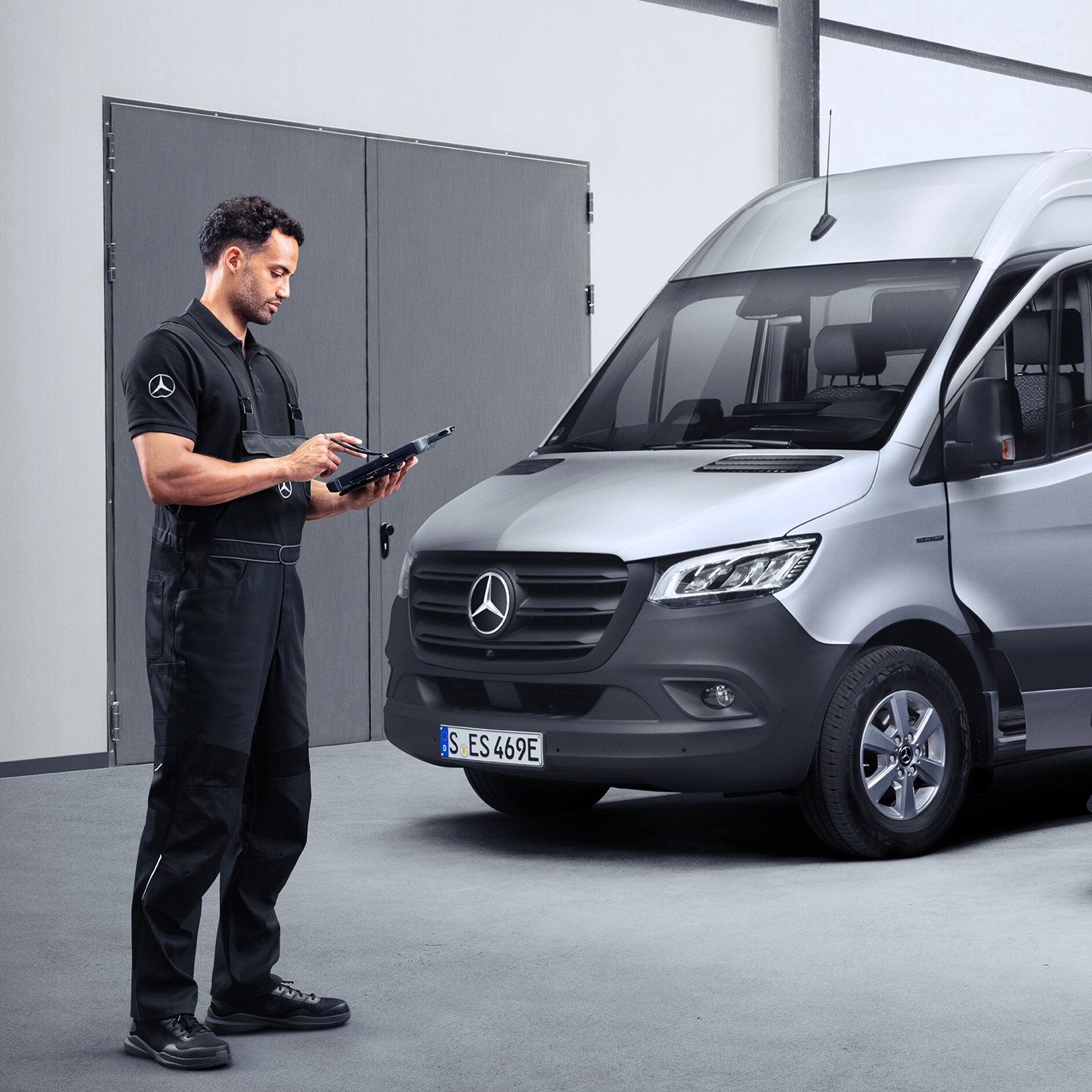 Mercedes-Benz servicemedarbejder med device foran Sprinter Kassevogn