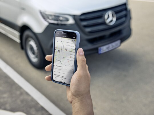 Den digitale tjeneste for e-mobilitet vises på en smartphone med en varebil i baggrunden