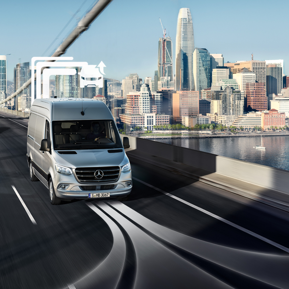 Van Uptime Monitor | Digitale tjenester | Mercedes-Benz En Mercedes-Benz varevogn køres over en bro med skyline i baggrunden.
