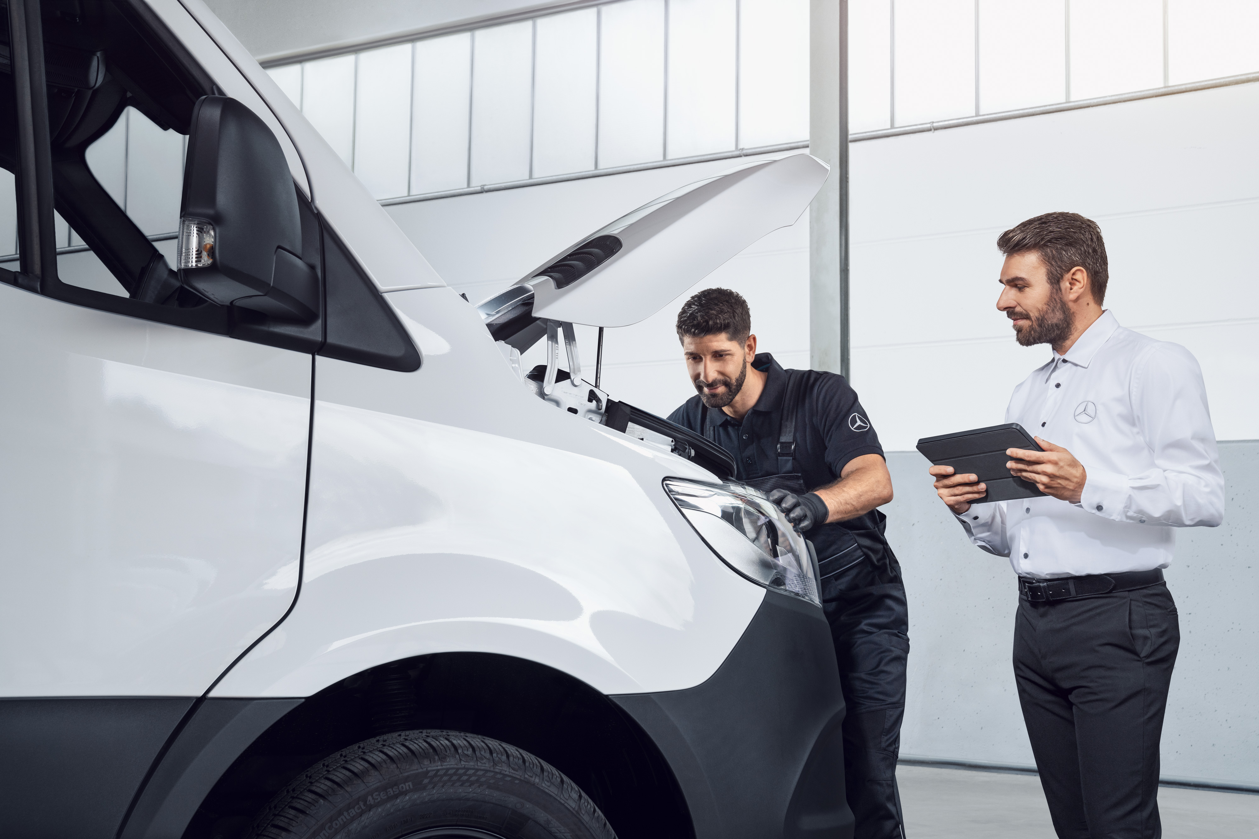 Mercedes-Benz | Originaldele til varebiler To Mercedes-Benz medarbejdere tester en Sprinter med tablet og åben motorhjelm.