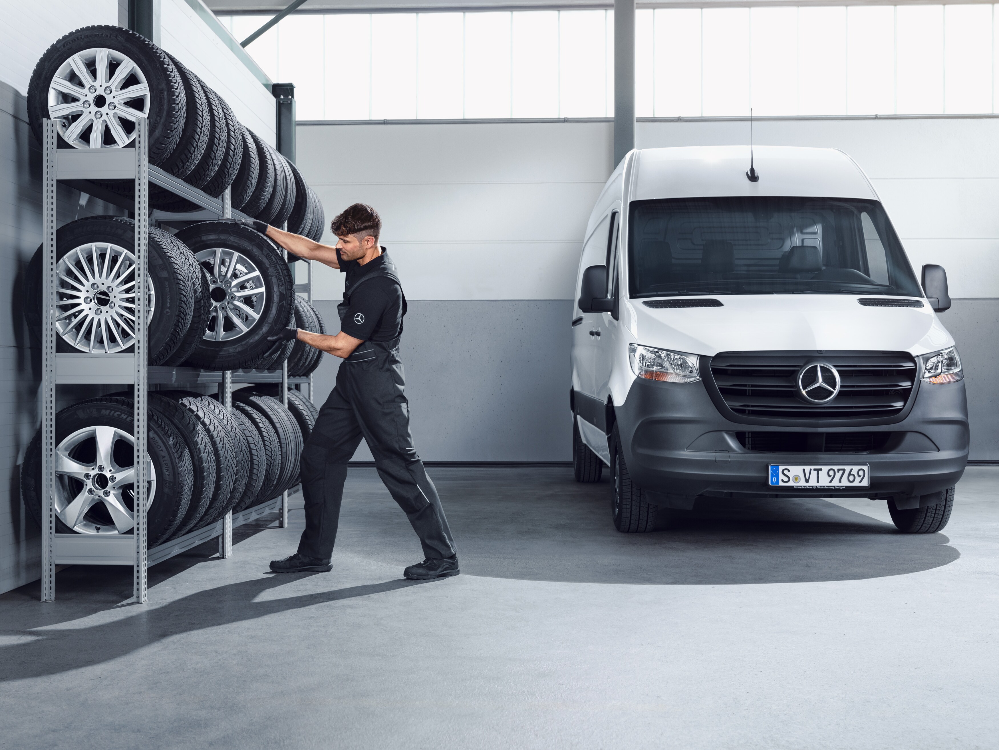 Mekaniker vælger Mercedes-Benz komplette vinterhjul fra hylden på værkstedet.