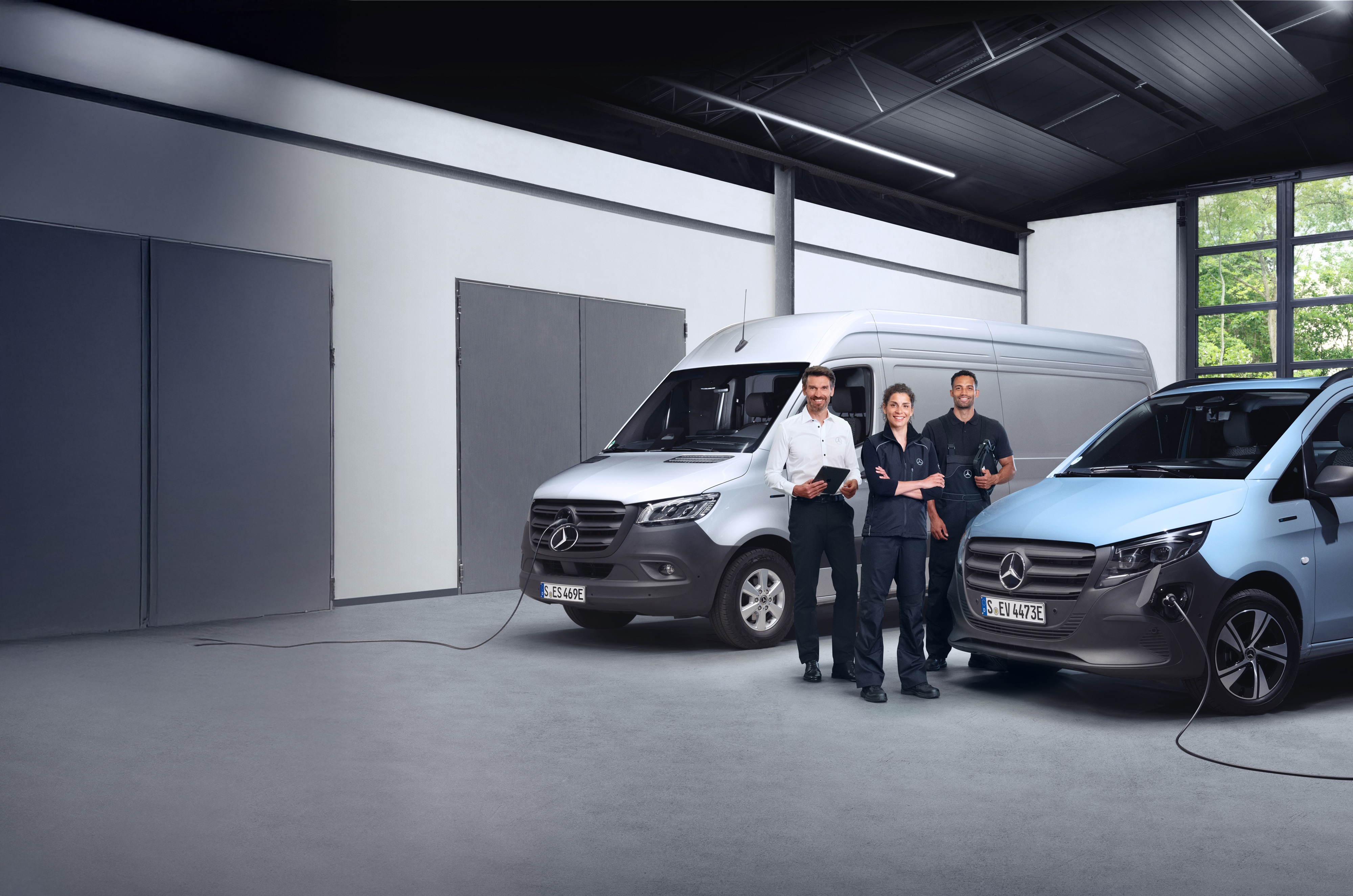 Mercedes-Benz | Varebiler kvalitetsoversigt Tre medarbejdere foran to elektriske Mercedes-Benz varebiler.