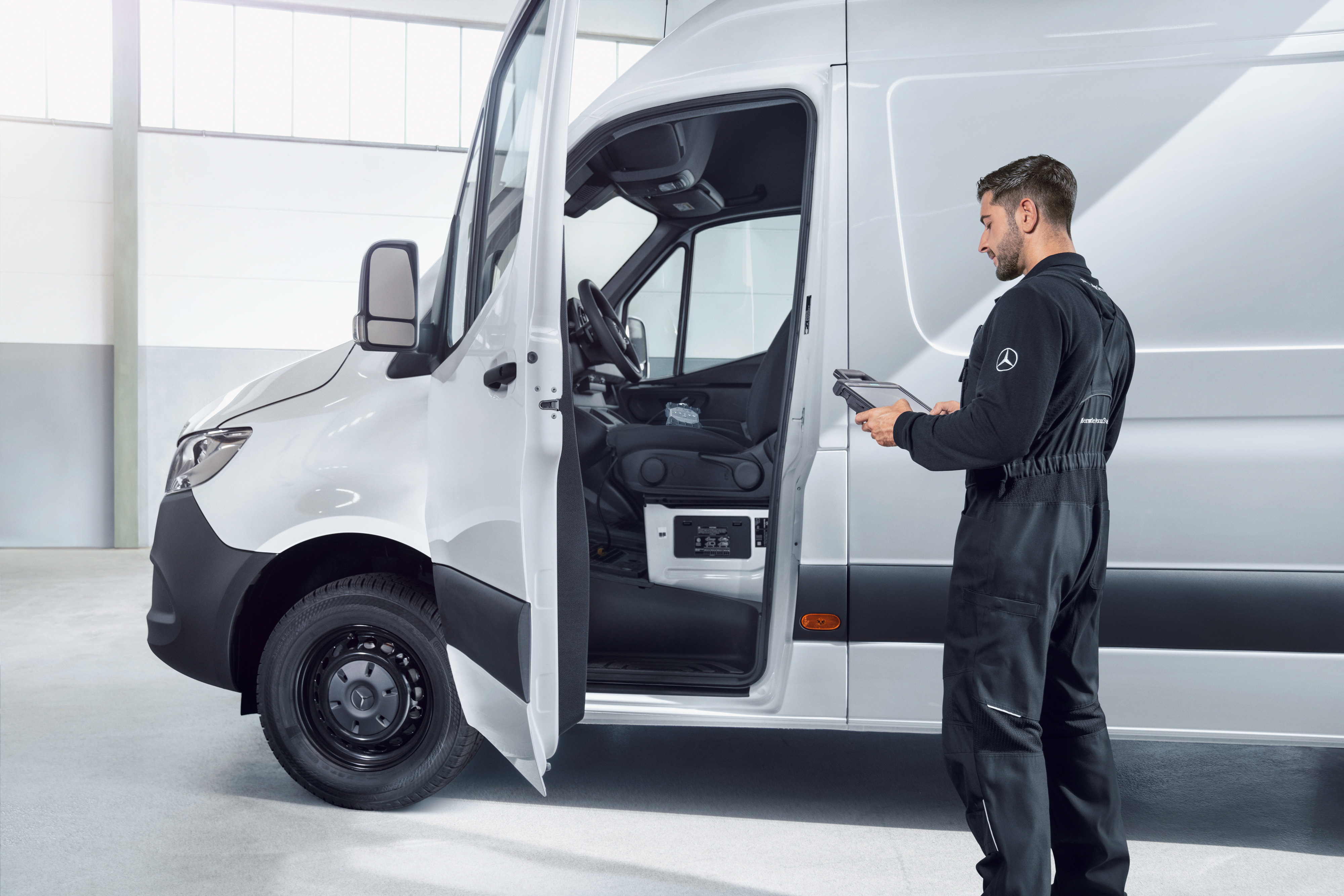 Mercedes-Benz | Varebiler kvalitetsoversigt Mekaniker tjekker en hvid Mercedes-Benz varebil med en tablet.