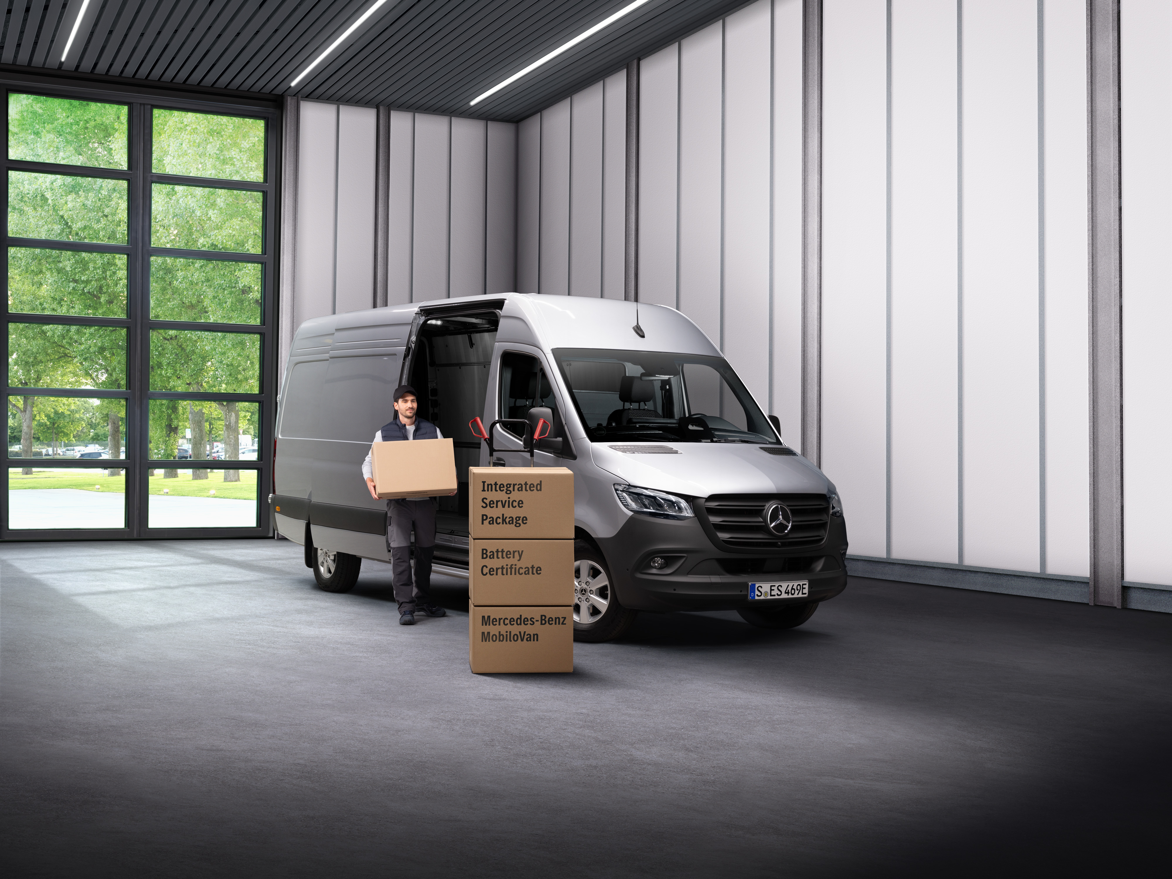 Mercedes-Benz | Service på elbiler En medarbejder fra Mercedes-Benz' elektriske service bærer kasser ud af en varevogn.