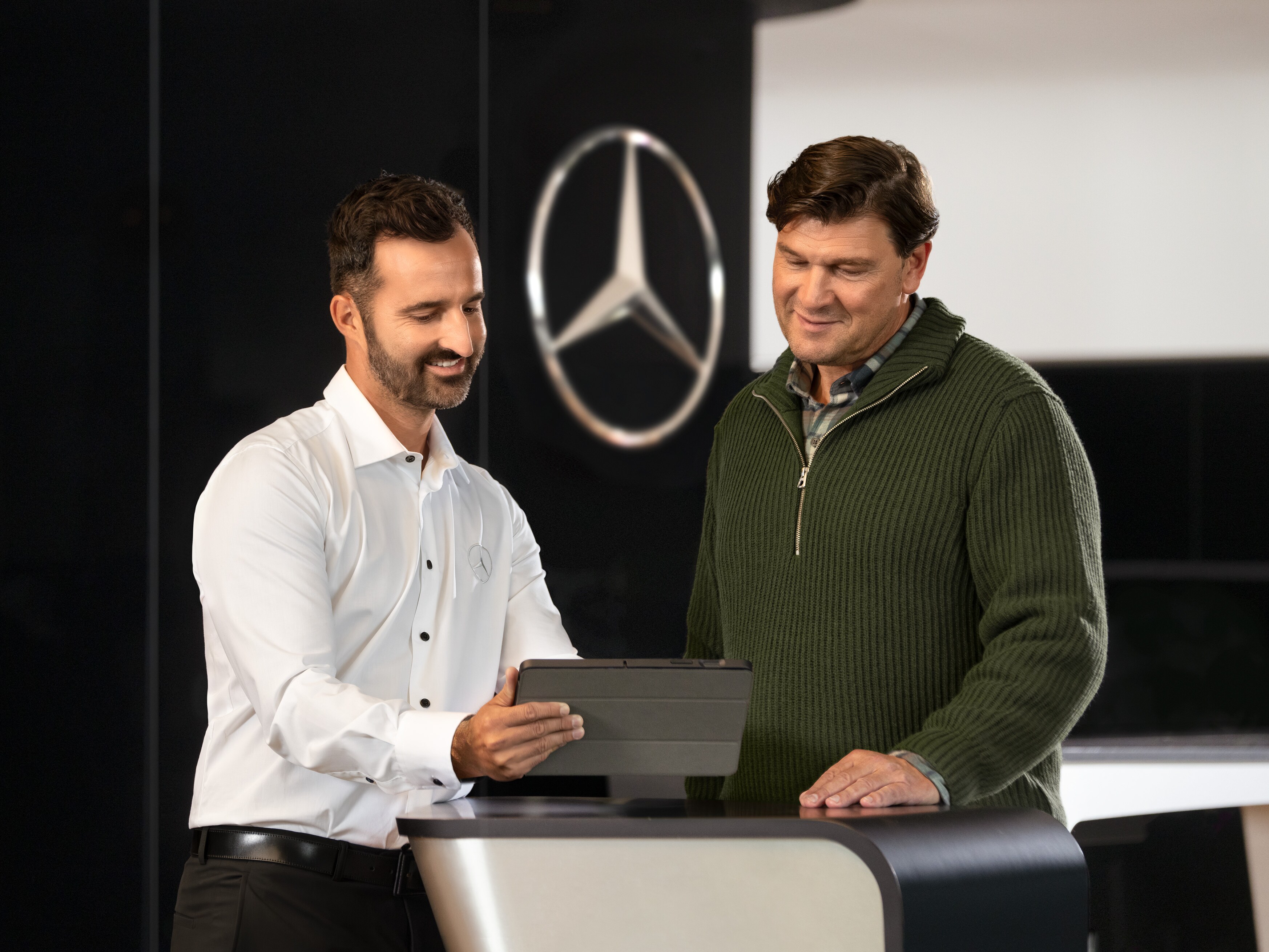 Mercedes-Benz medarbejder taler med kunde i et showroom.