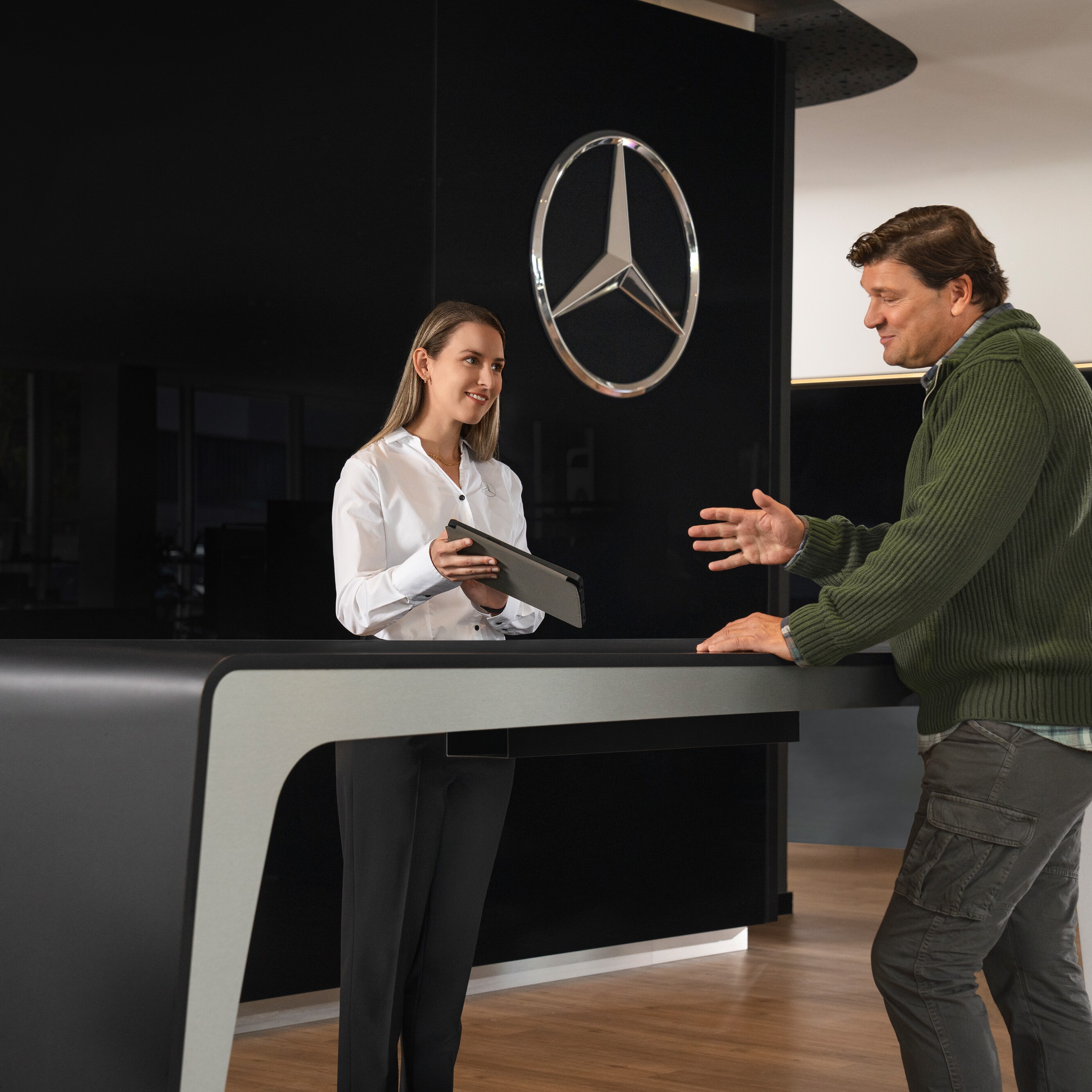 En Mercedes-Benz medarbejder rådgiver kunde i et showroom.